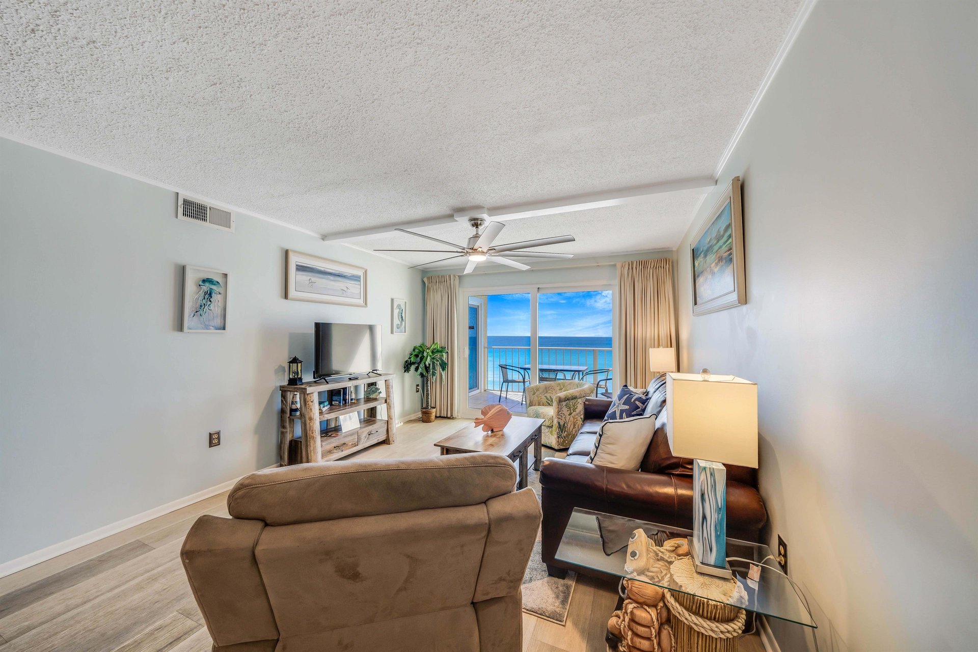 The living room offers ample, comfortable seating, a relaxing recliner, a large television, and gulf views.