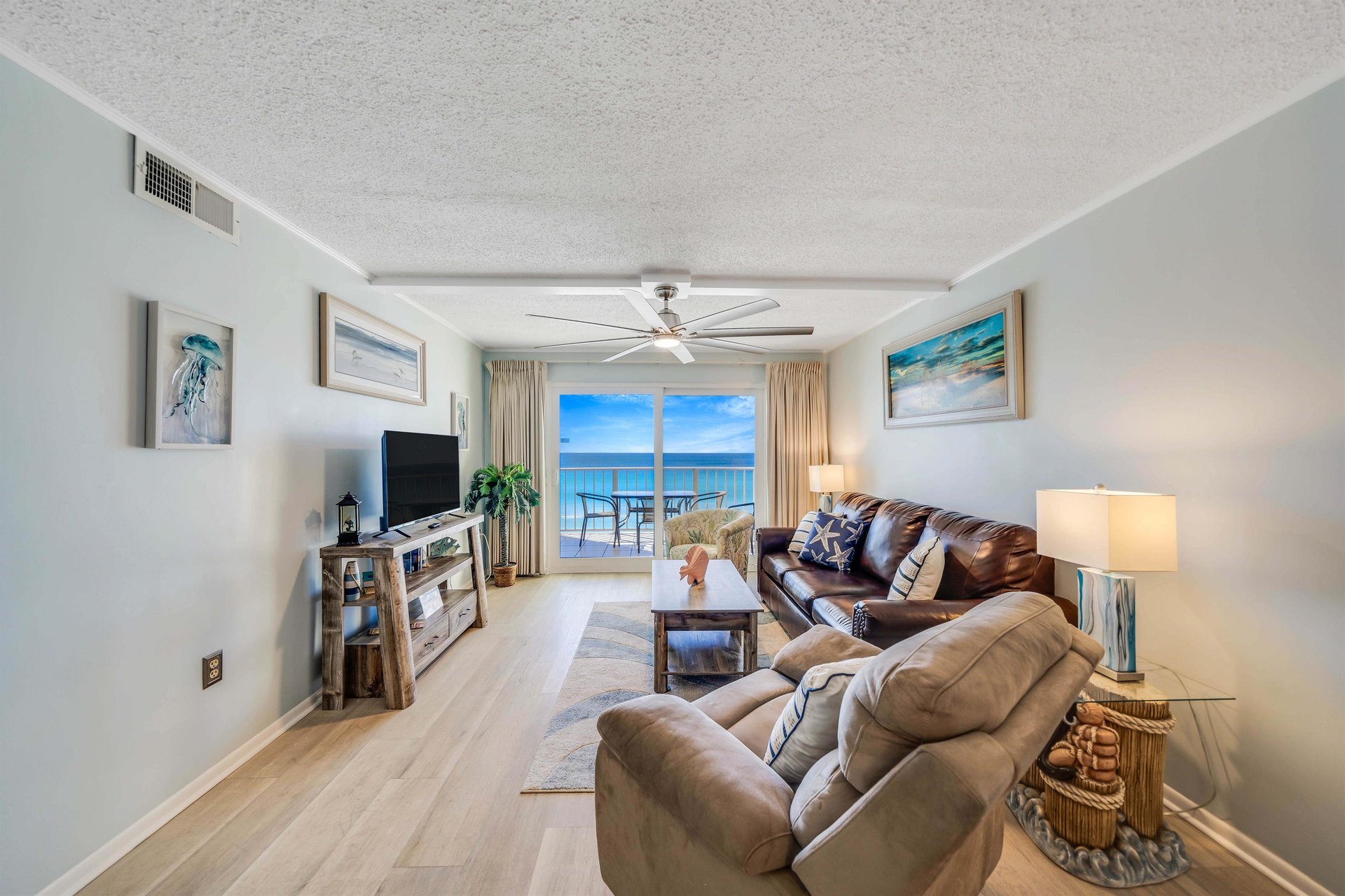 The living room offers ample, comfortable seating, a relaxing recliner, a large television, and gulf views.