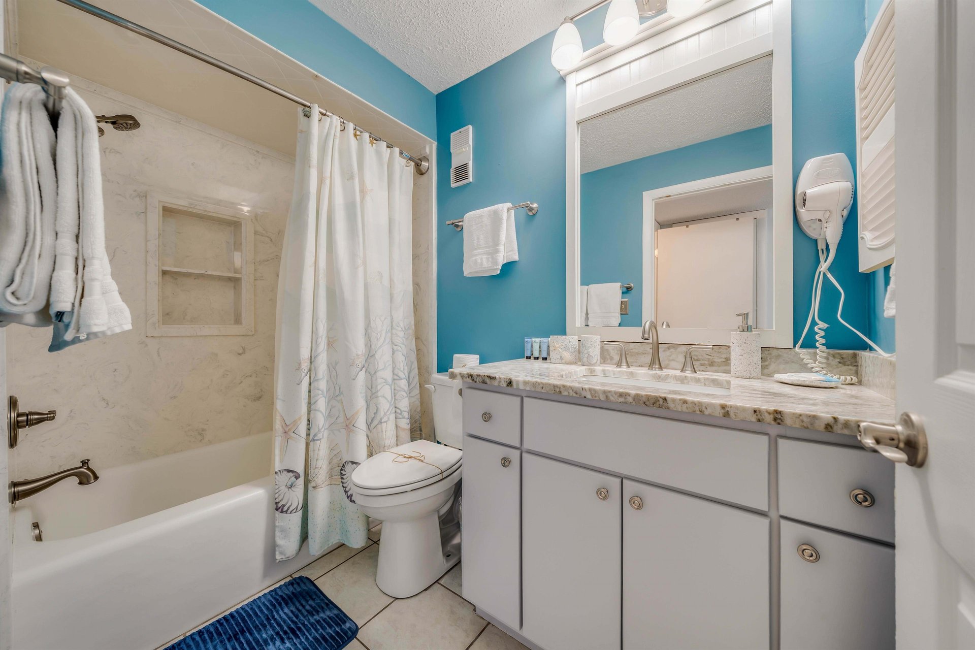 The second full bathroom is located off the hall, making it easily accessible for any guests sleeping on the pullout sofa. It also features quartz countertops and a tubshower combo.