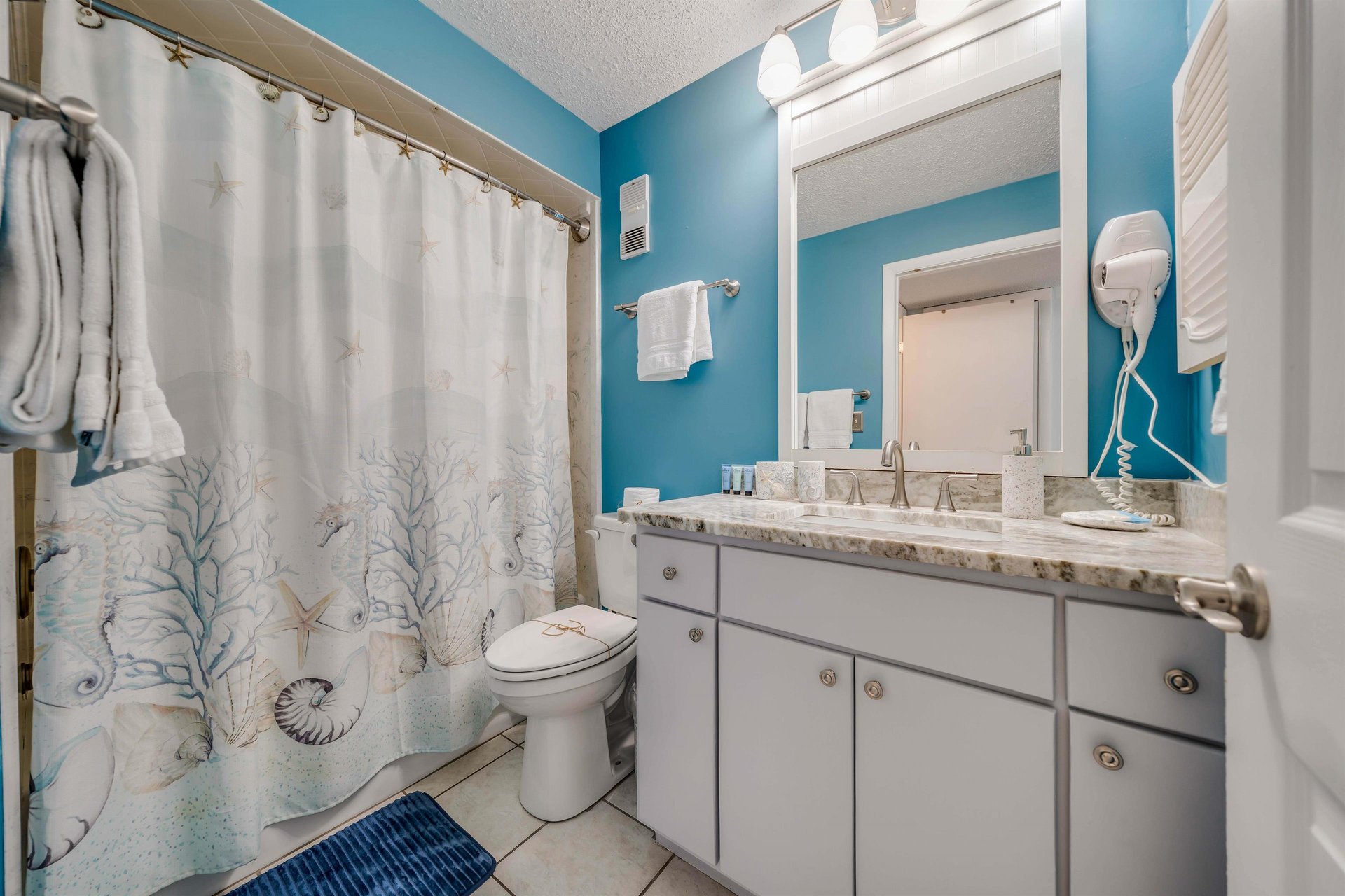The second full bathroom is located off the hall, making it easily accessible for any guests sleeping on the pullout sofa. It also features quartz countertops and a tubshower combo.