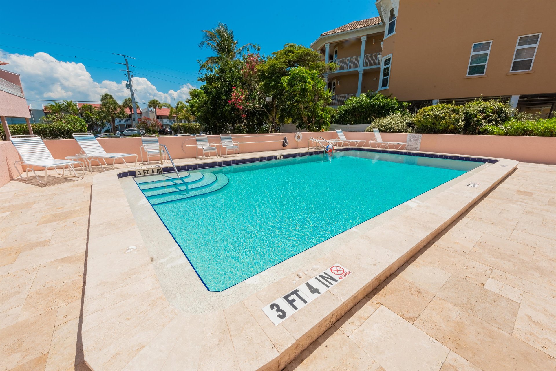Community pool with sun loungers