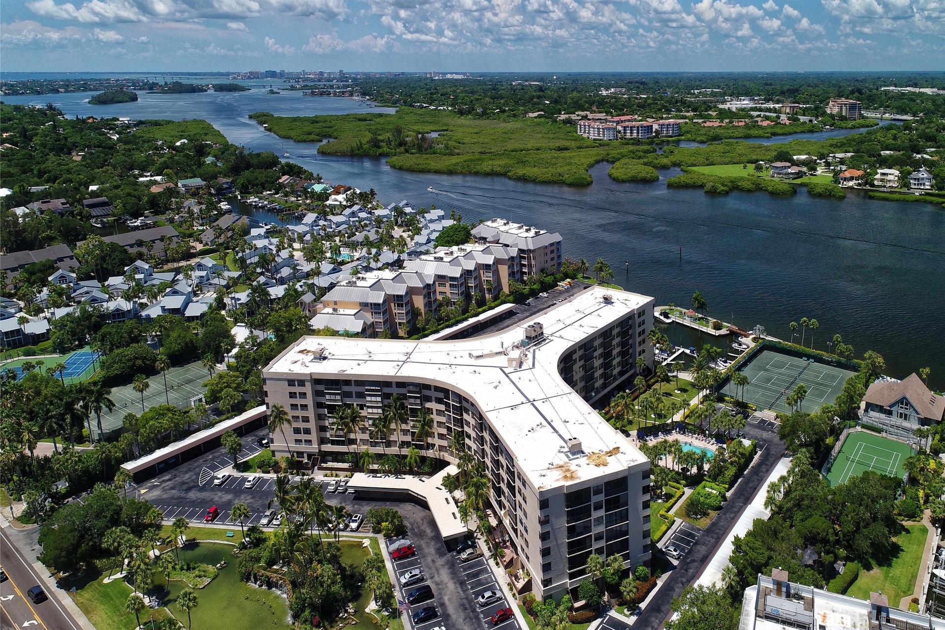 Waterfront resort property situated along scenic coastline with tennis courts, swimming pool, and abundant natural surroundings.