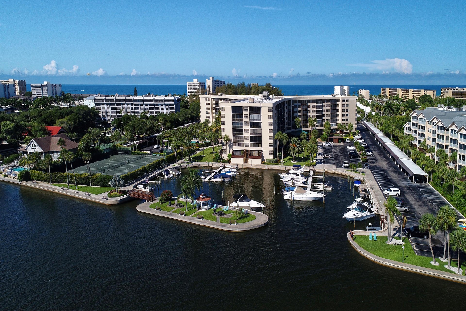 Waterfront community featuring marina access, resortstyle buildings, and tropical landscaping near pristine coastal waters.