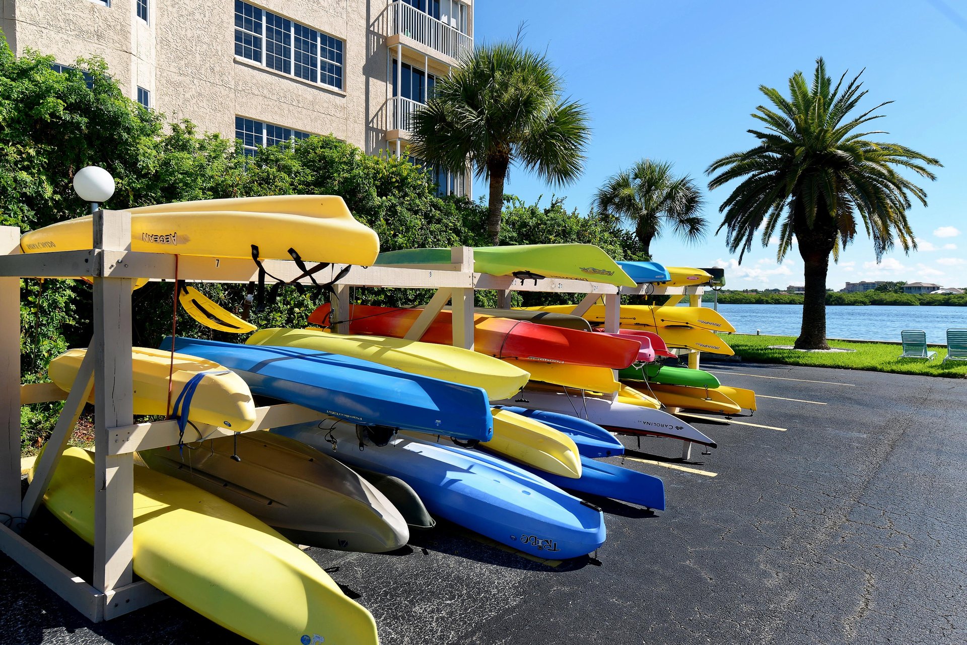 Colorful kayaks await your waterfront adventure, with tropical palms and scenic lake views creating the perfect vacation backdrop.