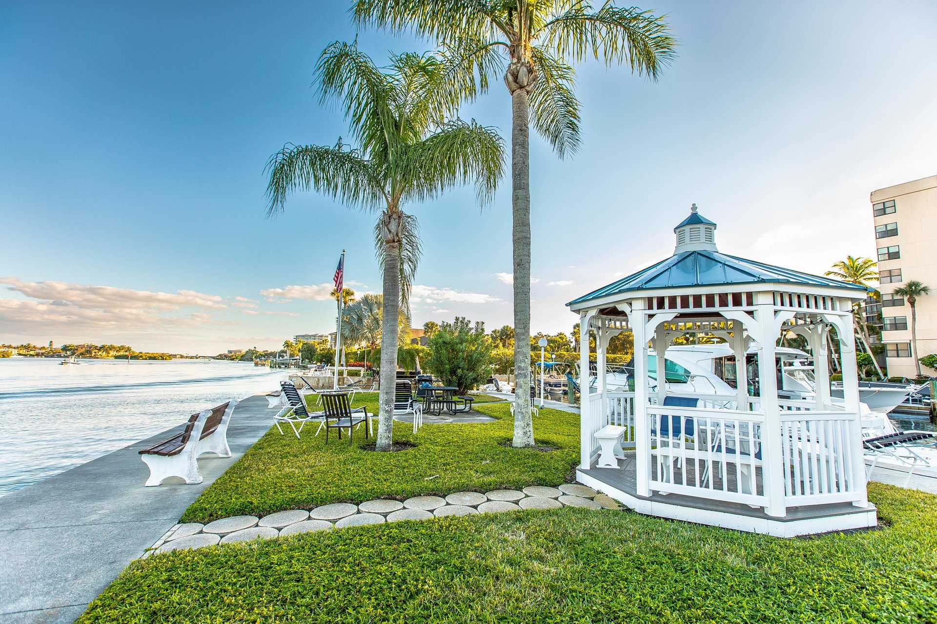 Waterfront property featuring a charming gazebo, palmlined lawn, and direct access to scenic bay views with boat docks.