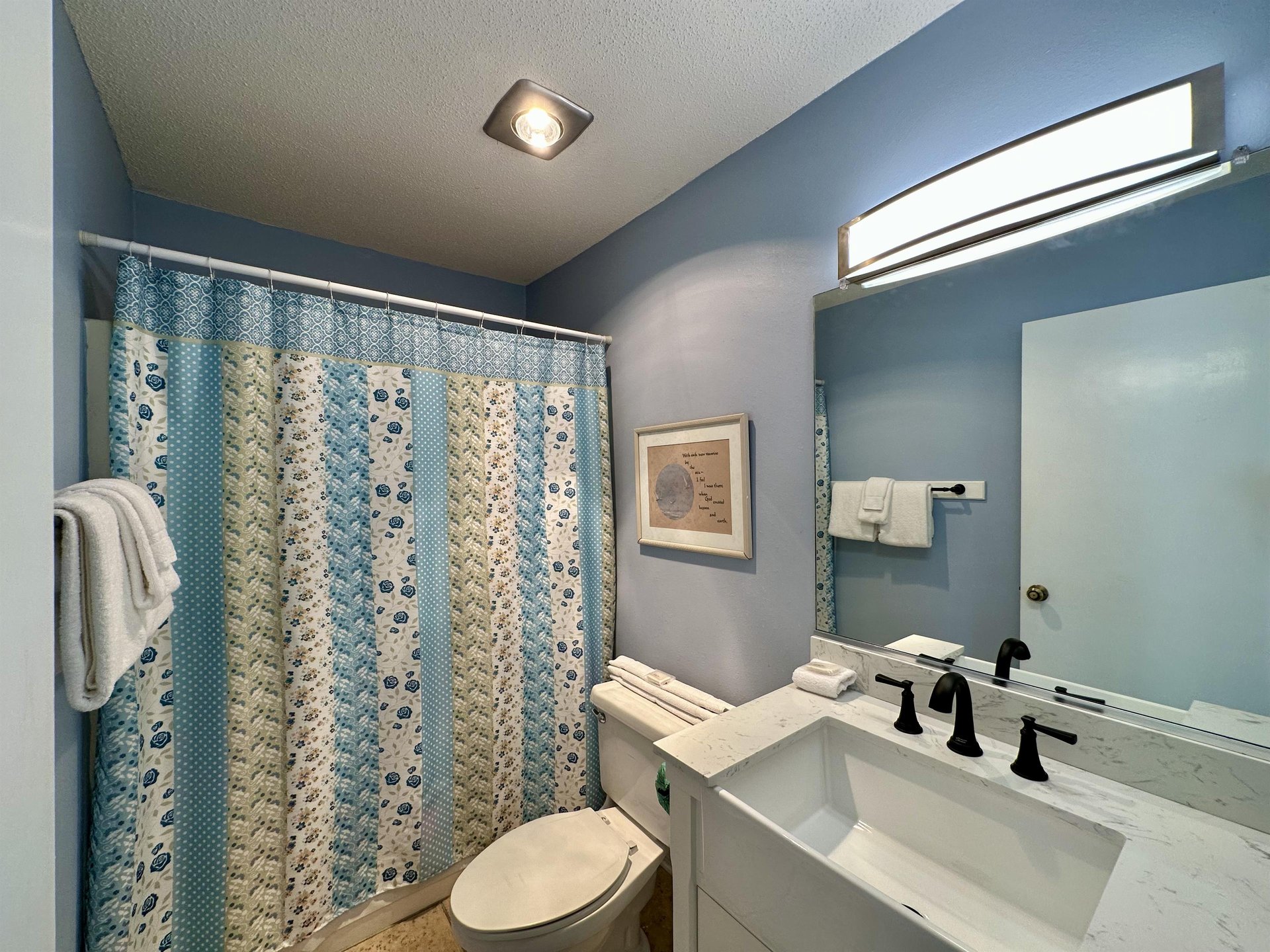 Your private bathroom features calming blue tones, crisp white linens, and modern fixtures for a refreshing start to each day.