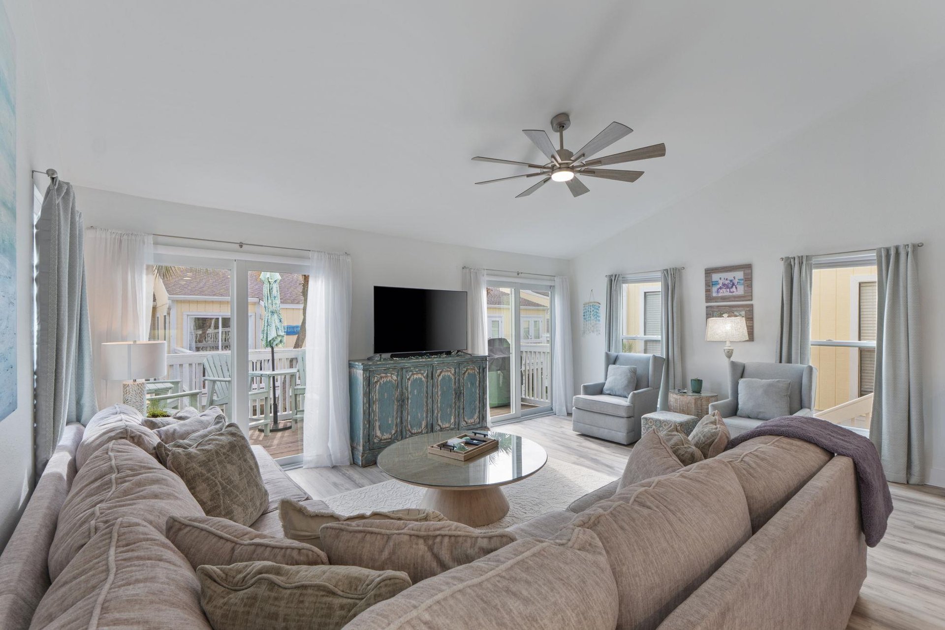 Sink into plush sectional seating where coastal breezes flow through your bright living space, perfect for relaxing after beach days.