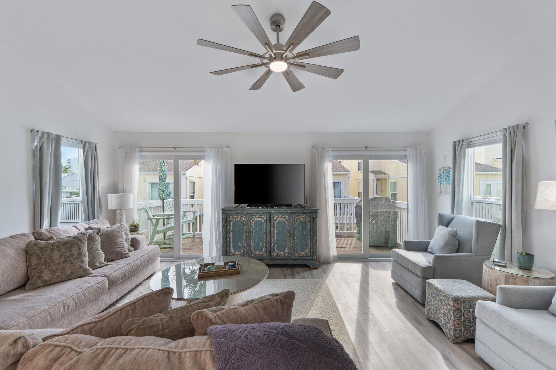 Sink into plush seating while enjoying coastal views through multiple windows in this bright, elegantly furnished living space.
