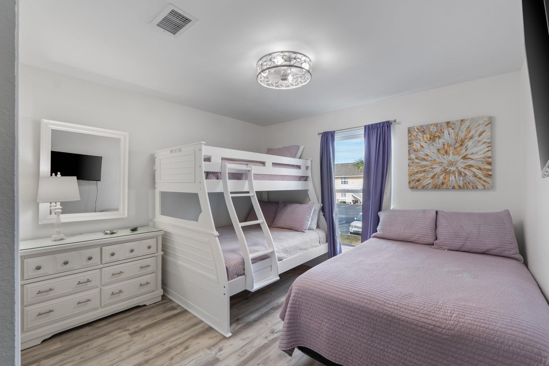 Settle into this spacious bedroom with soft lavender linens and plenty of room for the whole family to unwind comfortably together.