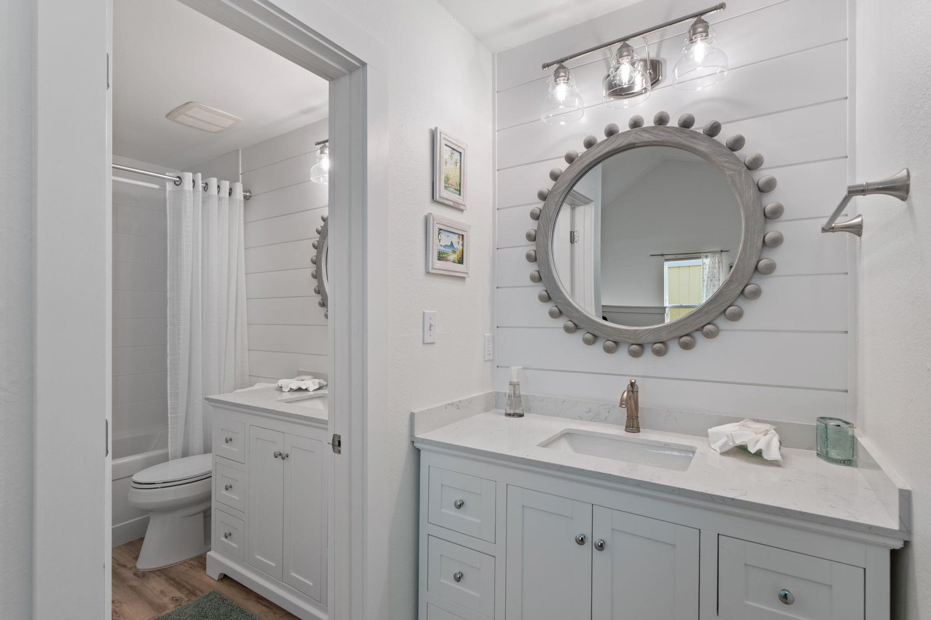 Your private coastalinspired bathroom features shiplap walls, marble counters, and thoughtful lighting for refreshing mornings.
