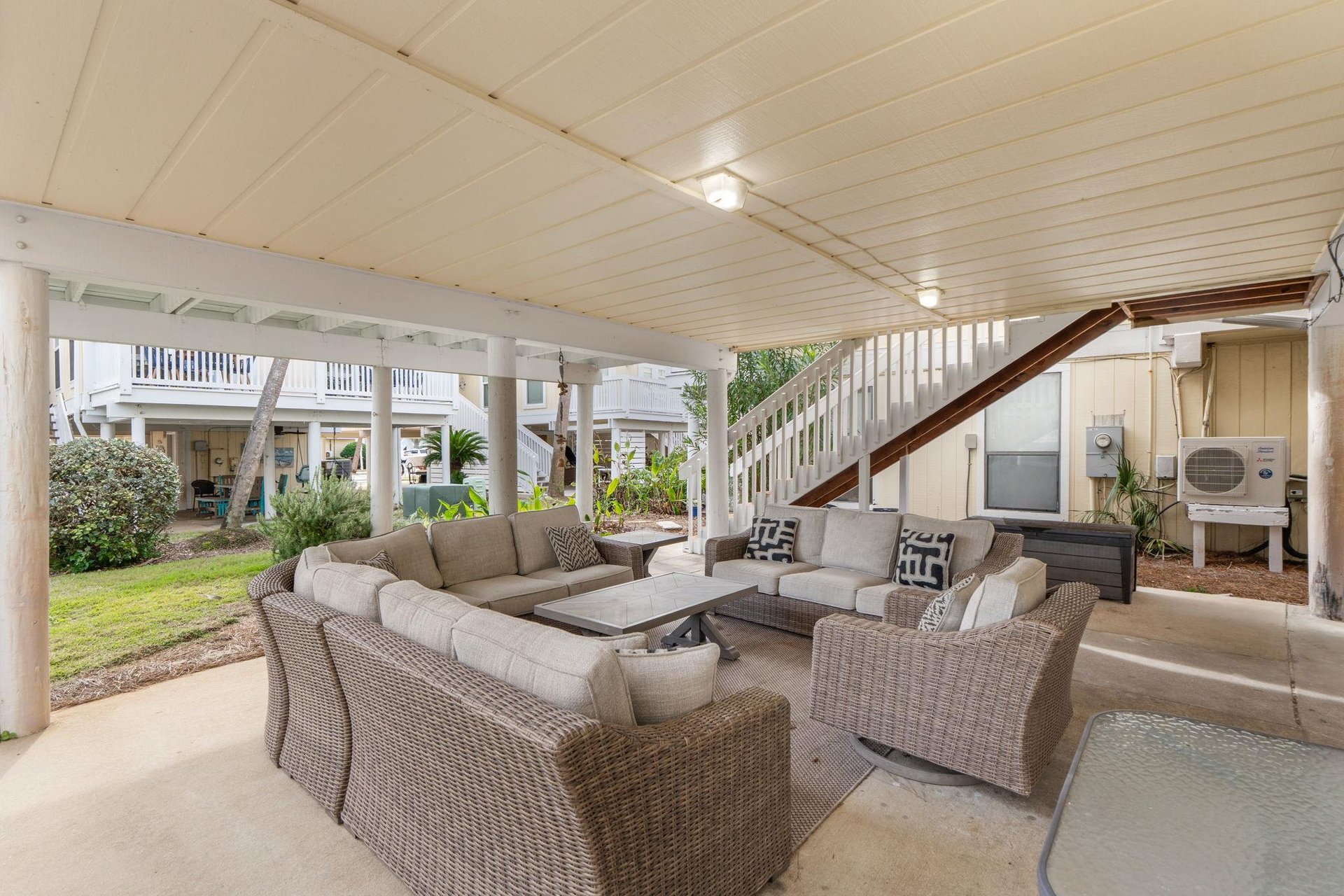 Gather around this spacious covered patio, where comfortable wicker seating invites you to unwind with loved ones in your own private outdoor sanctuary.