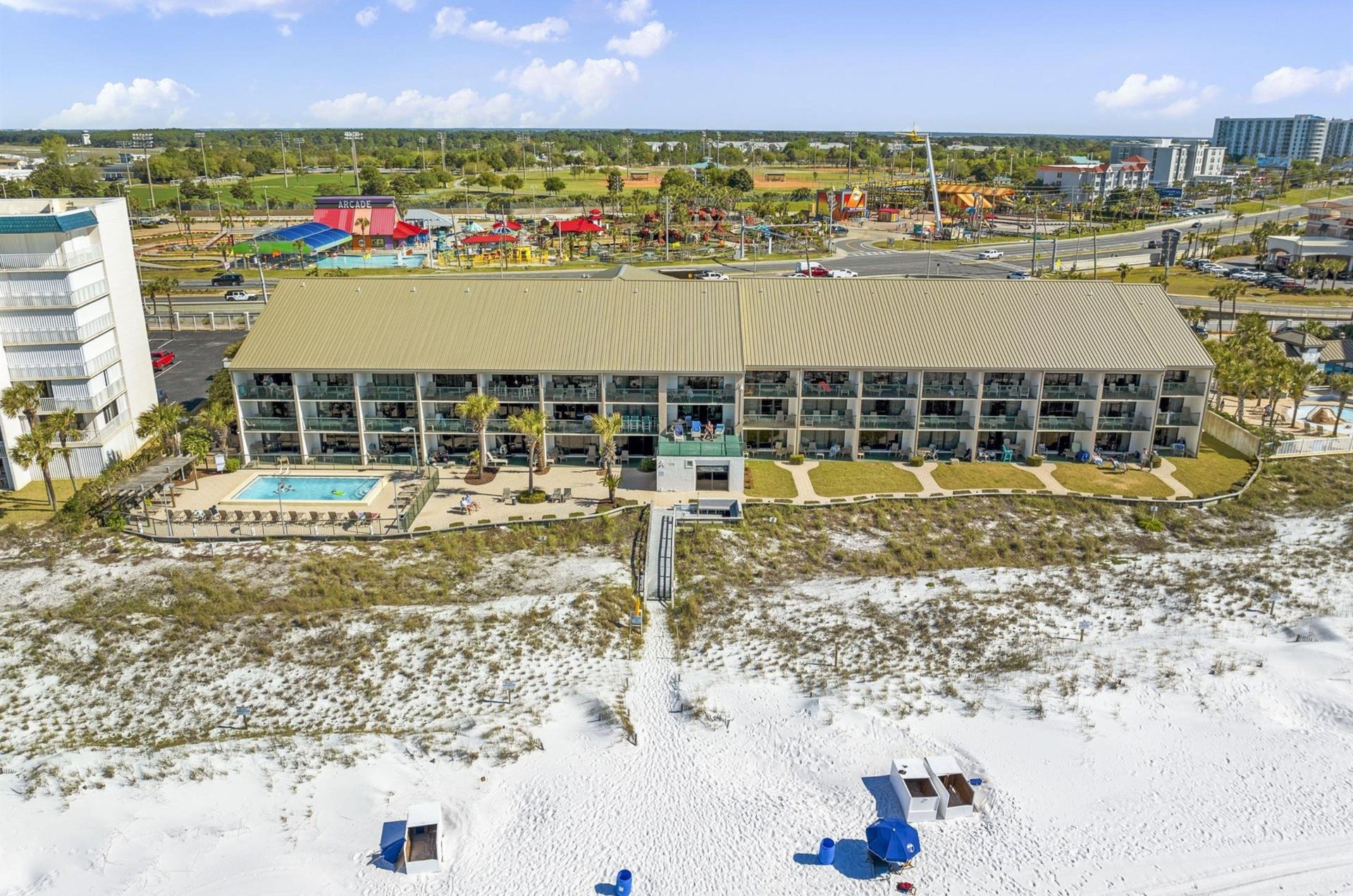 View from the beach of Destin Beach Club with a wooden boardwalk out front