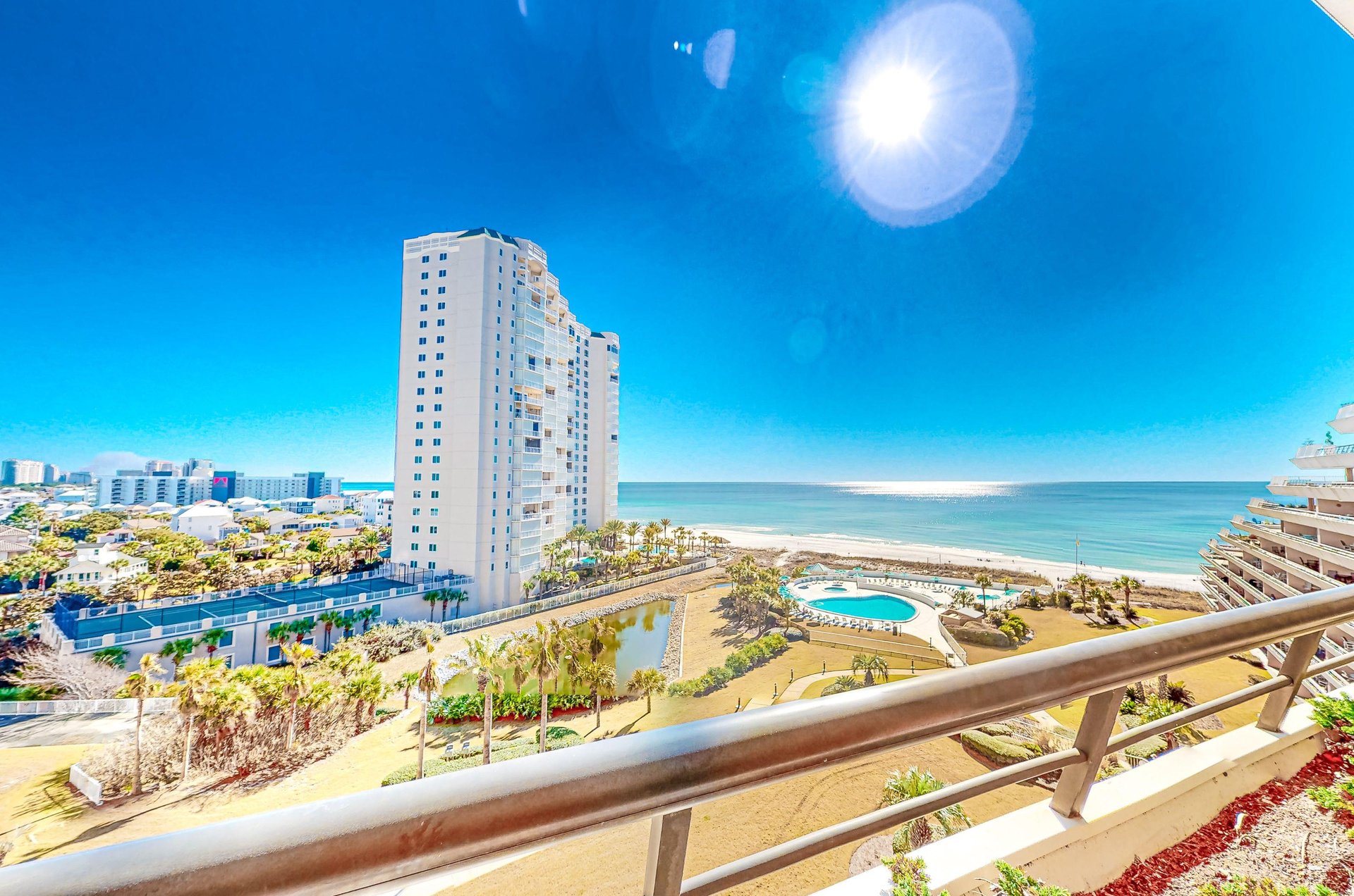 The sun shines down on Edgewaters pools, hot tubs, tennis courts, and lavish landscaping.