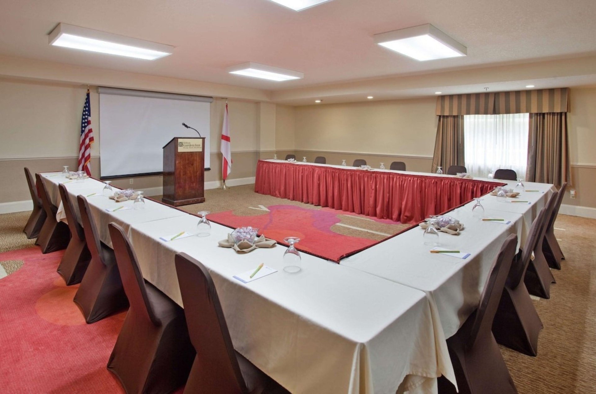 A meeting room with a podium and ushaped table at Hilton Garden Inn