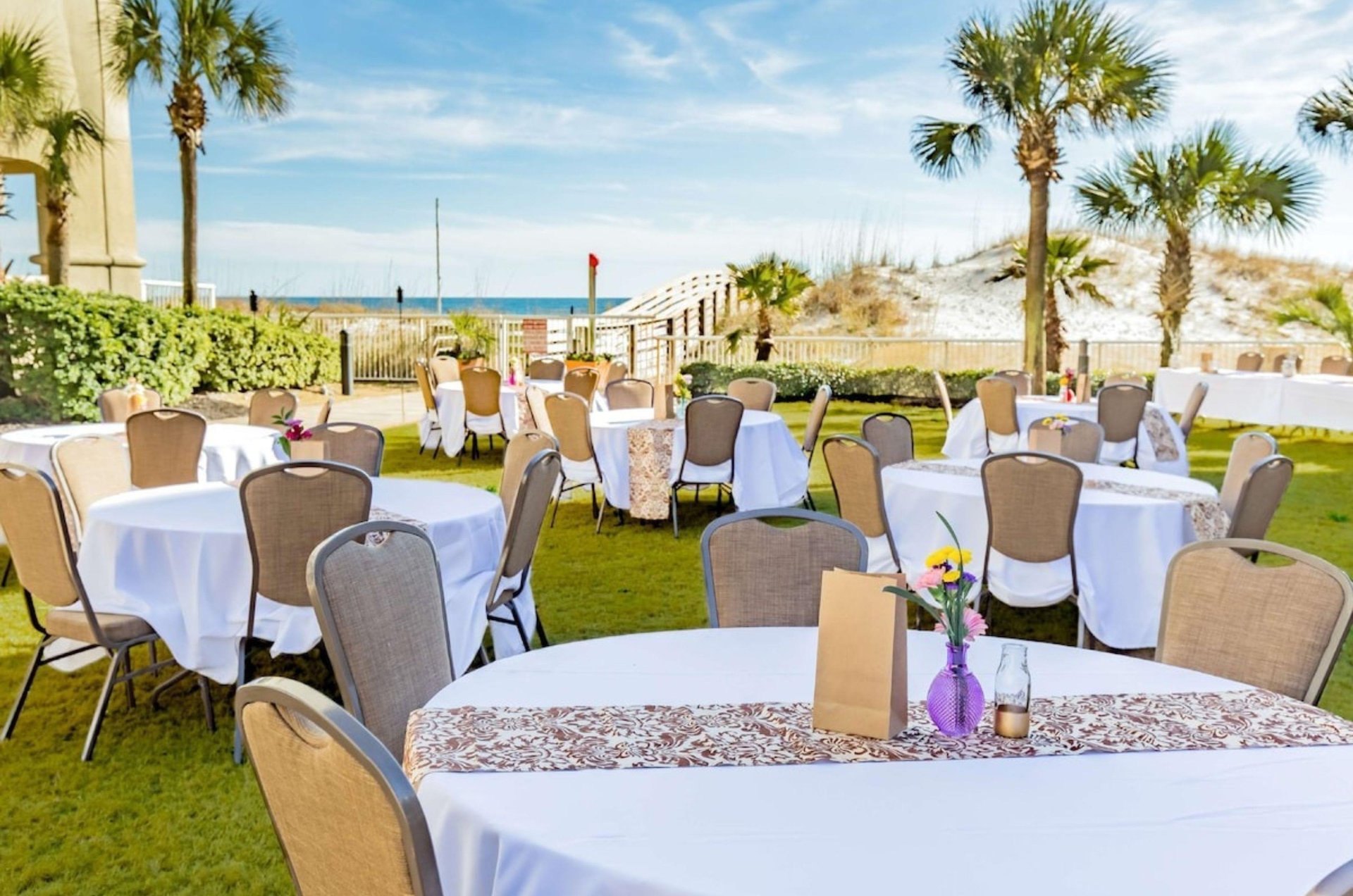 Dining tables and chairs on the beachside lawn at Hilton Garden Inn at Orange Beach Alabama