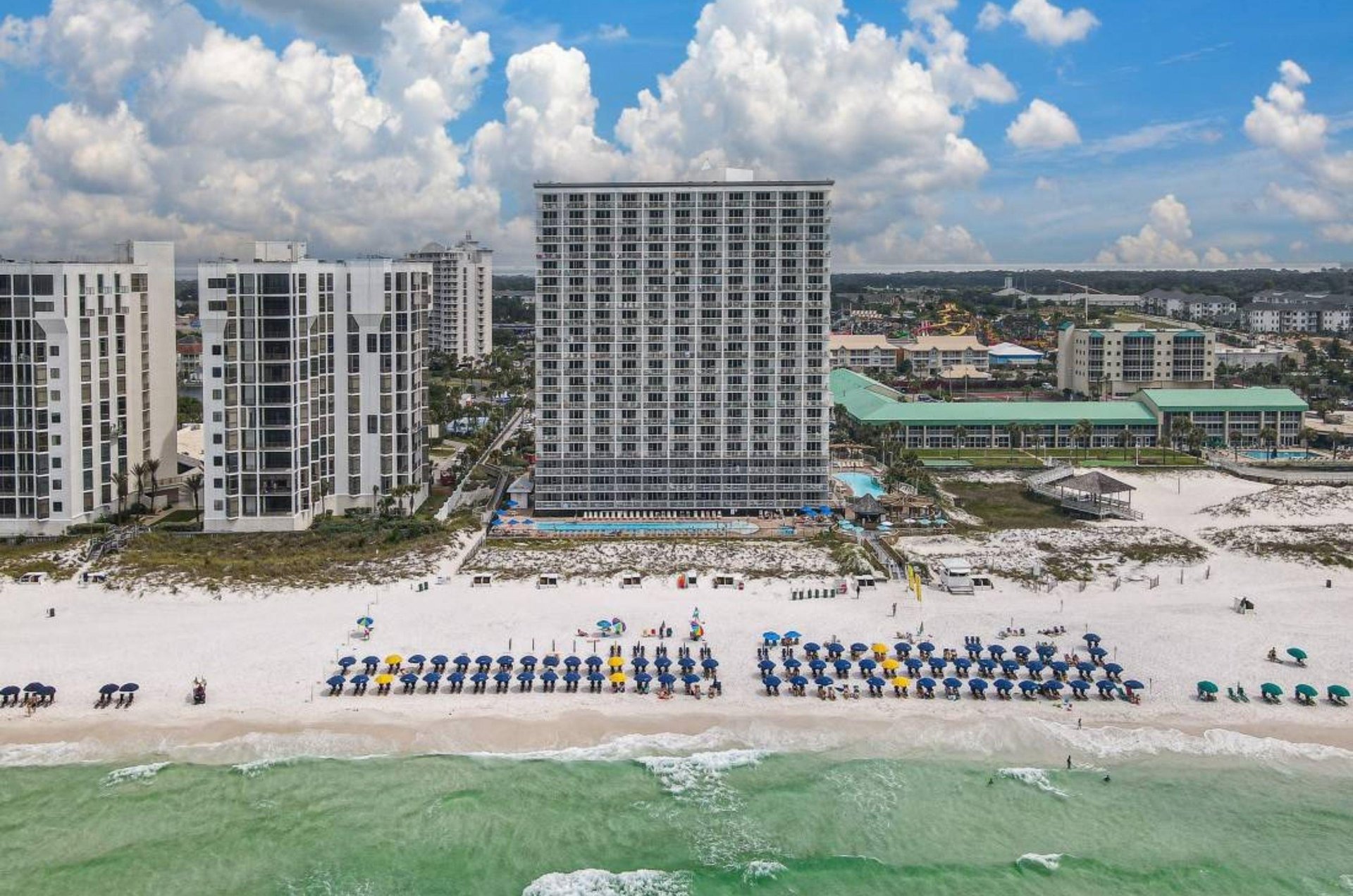 View of the Gulffront facade of Pelican Beach Resort with the beach in front
