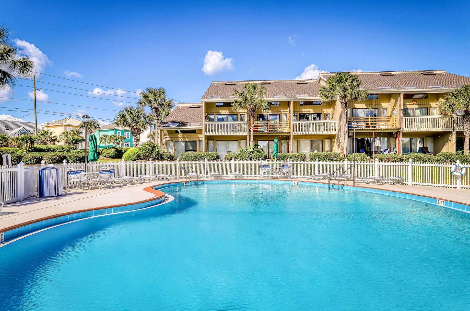 A sparkling community pool with chairs for sitting and lounging