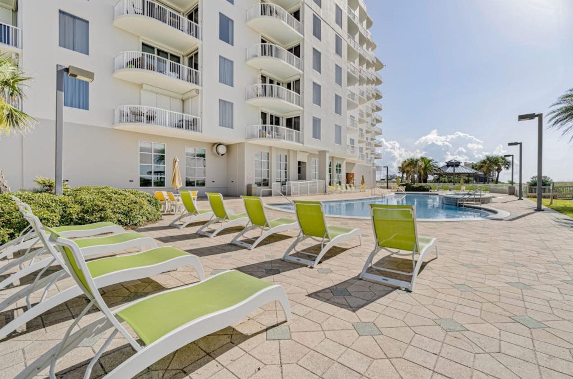 Lounge chairs on the Gulffront pool deck by the outdoor swimming pool at Spanish Key