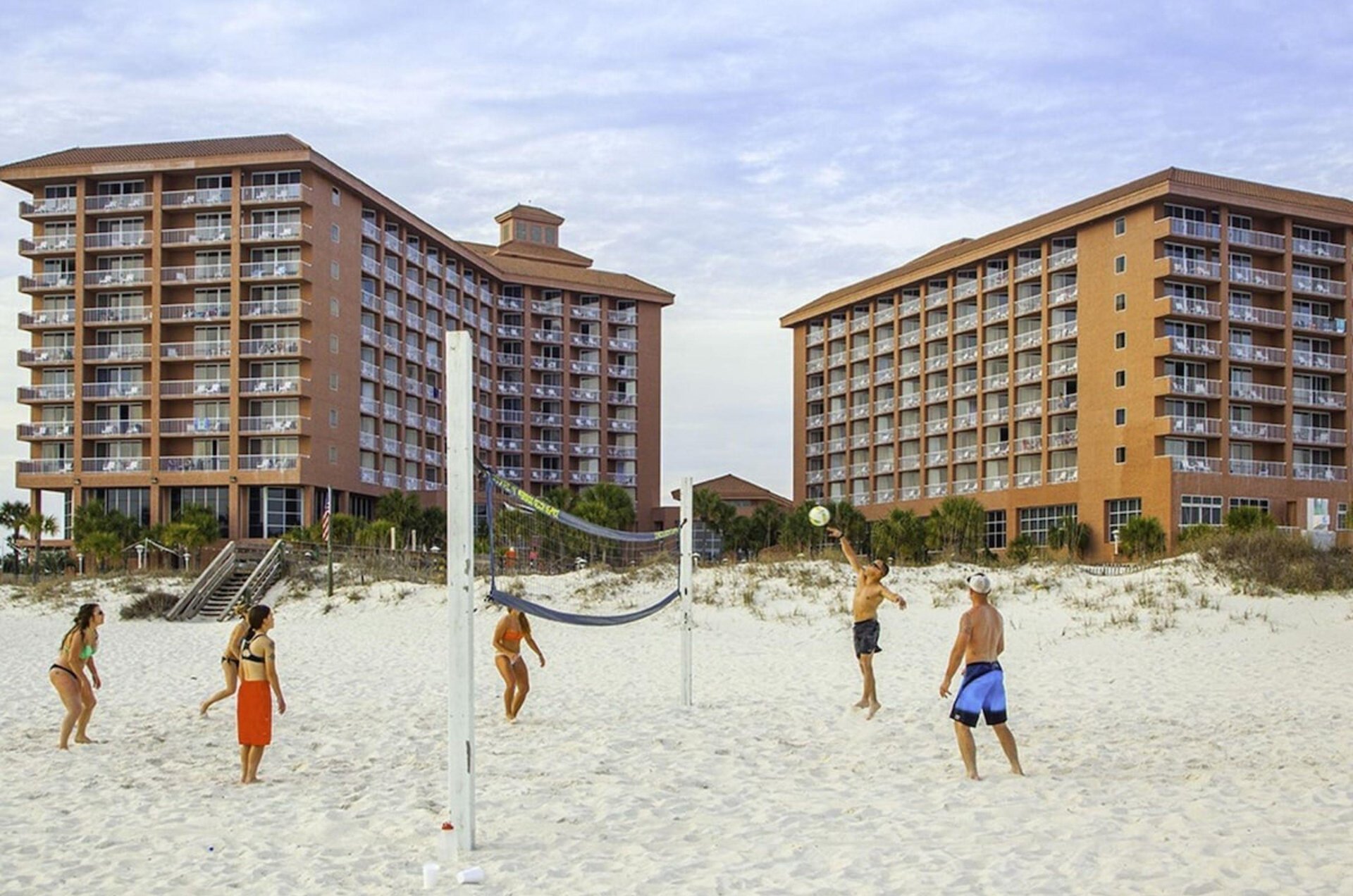 A group playing beach vollyball in front of Perdido Beach Resort in Orange Beach Alabama