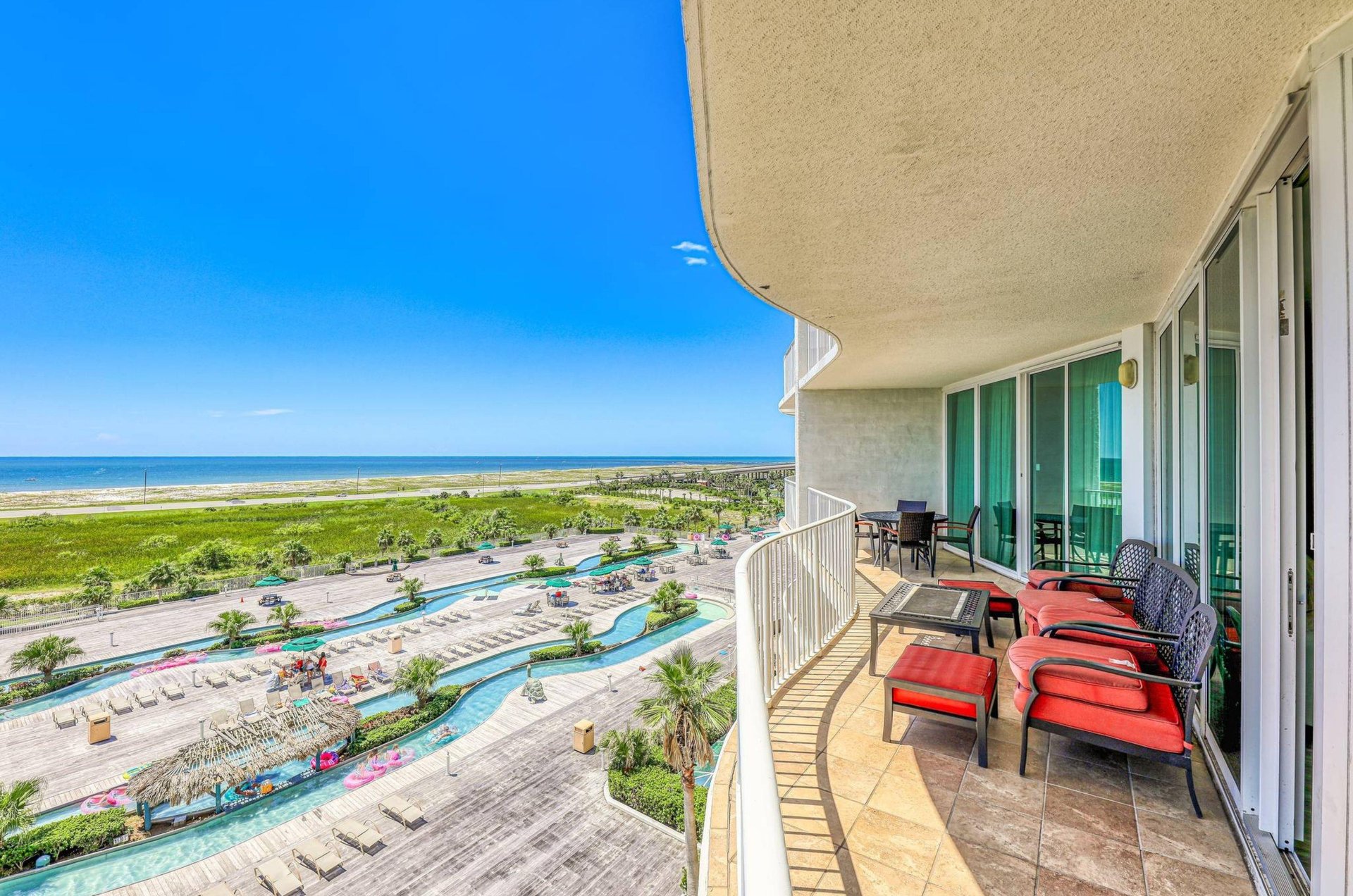 Lounge chairs on a private balcony overlooking the lazy river and the water at Caribe Resort