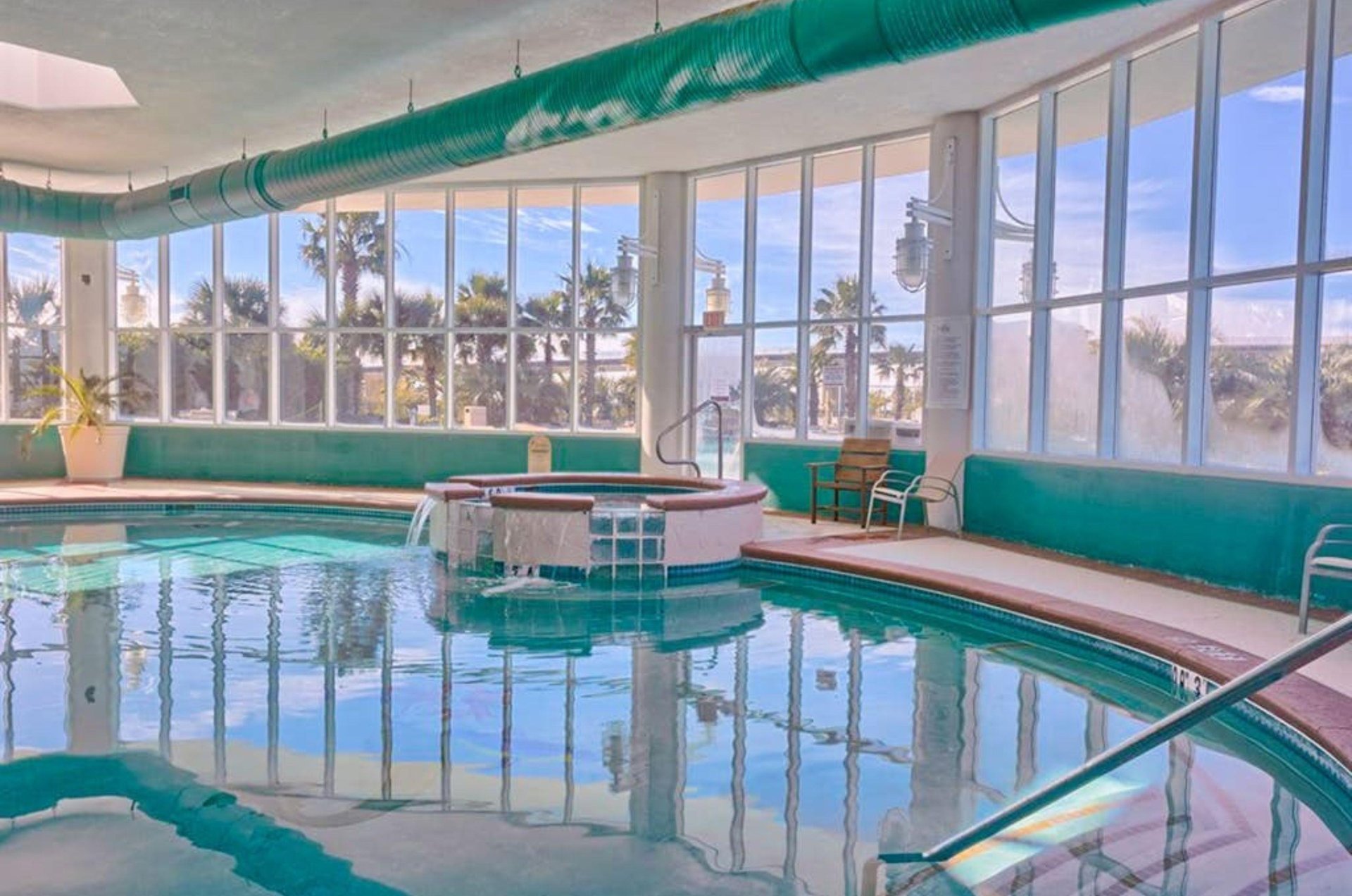 An indoor hot tub and swimming pool next to windows at Caribe Resort in Orange Beach Alabama