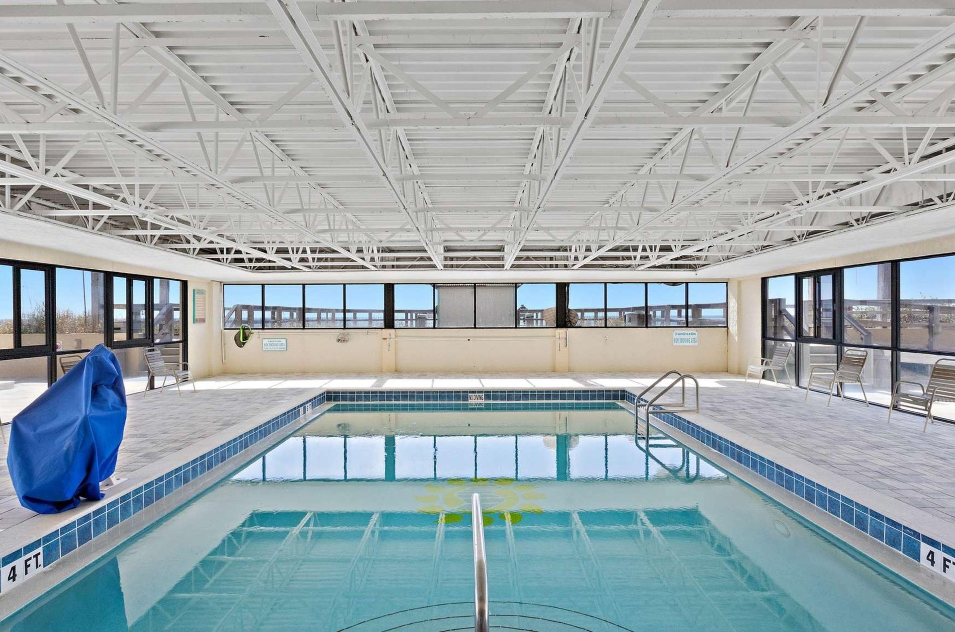 An indoor swimming pool with windows overlooking the Gulf at SunDestin Beach Resort in Destin Florida