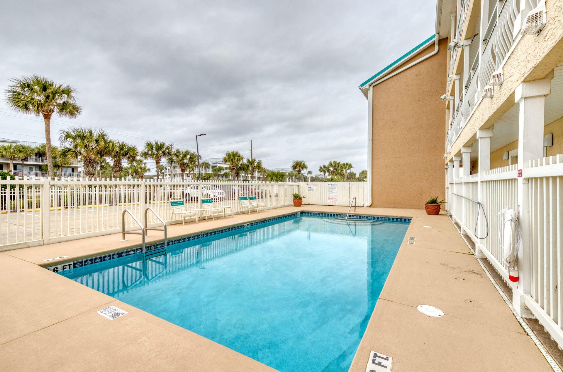 Crystal Sands sparkling swimming pool is surrounded by a fence.