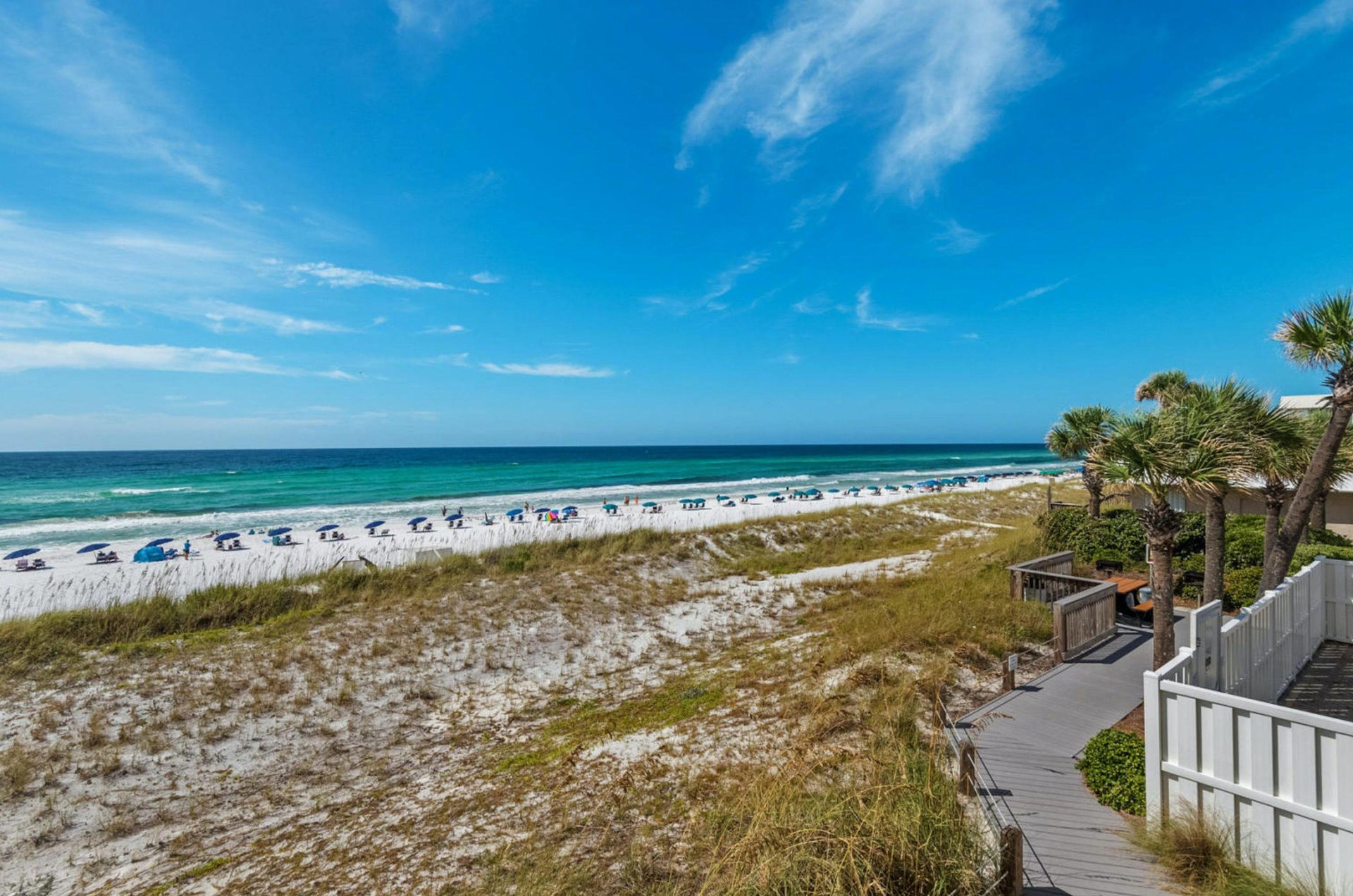 Crystal Sands private beach set up with beach chairs and umbrellas.