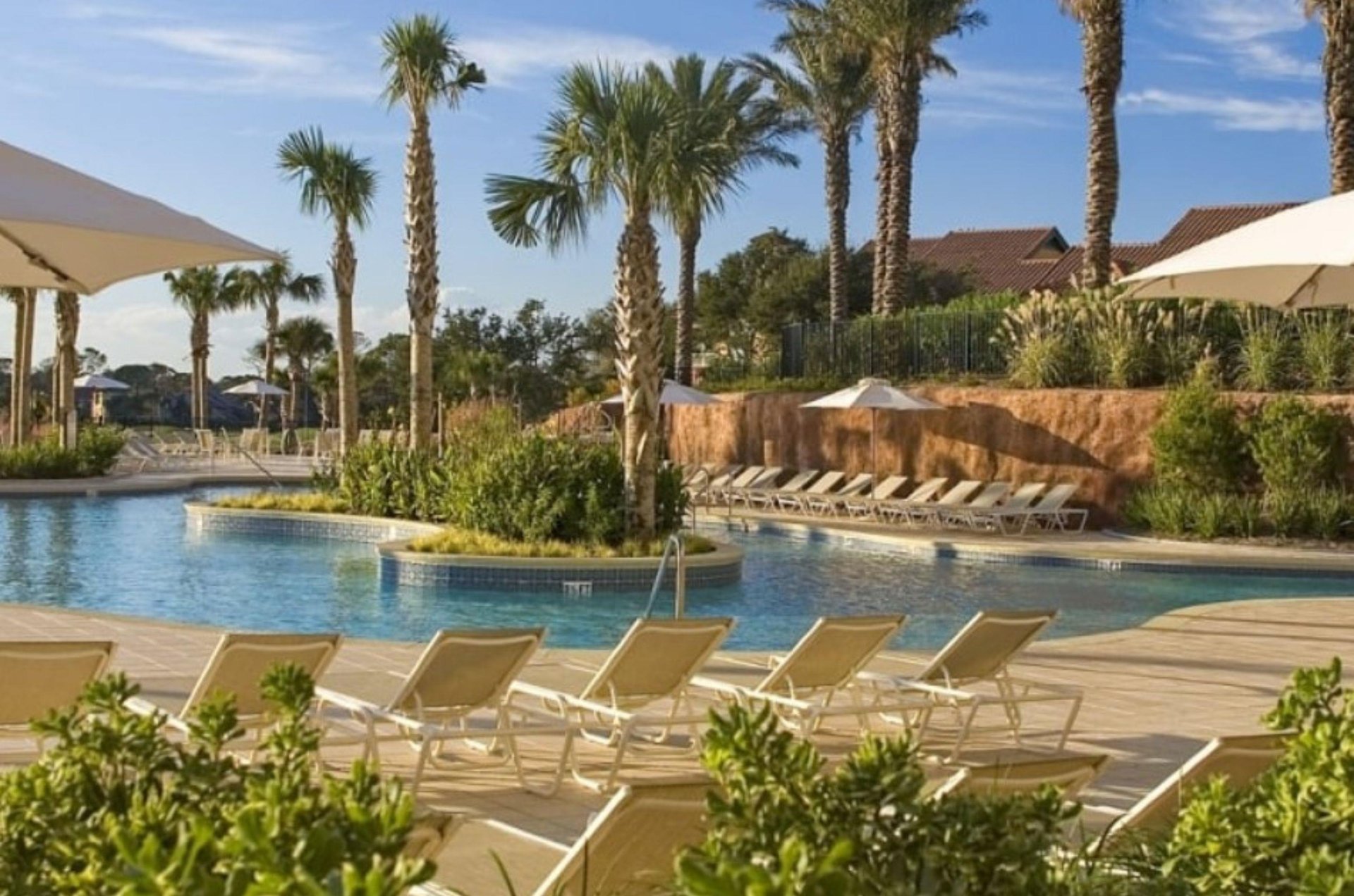 A community pool with lots of loungers for sunning and relaxing