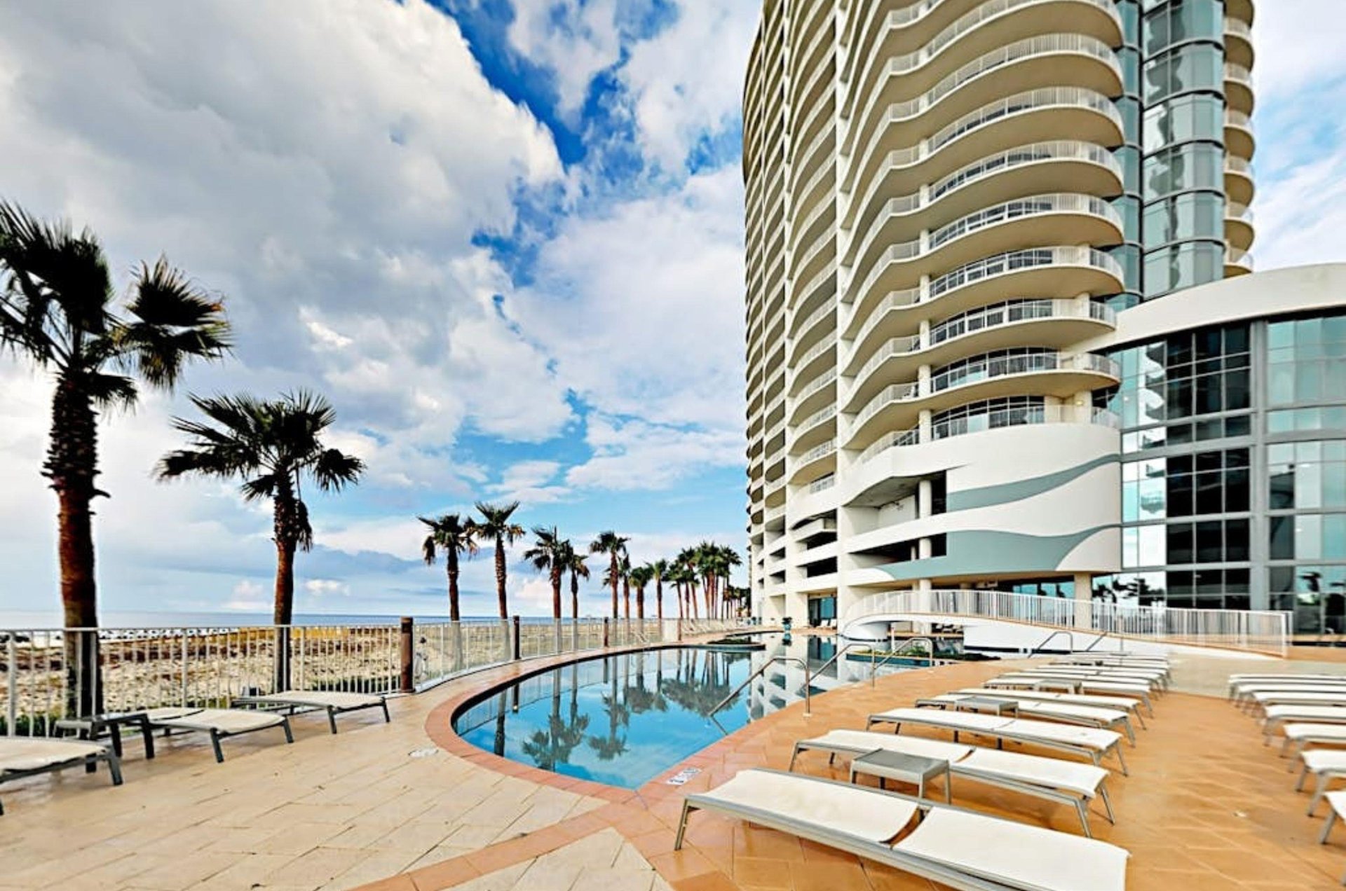 The lounge chairs on the pool deck next to the swimming pool at Turquoise Place