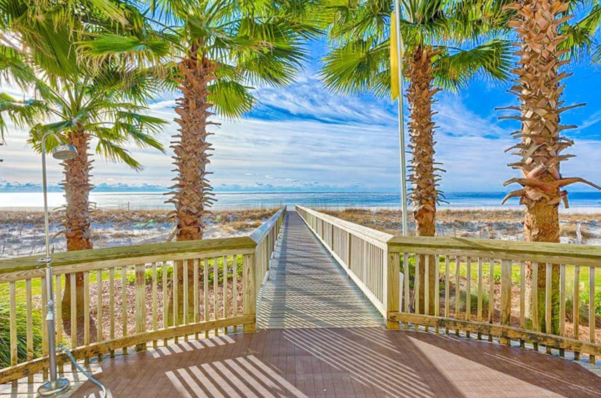 A wooden boardwalk leading to the beach and the water