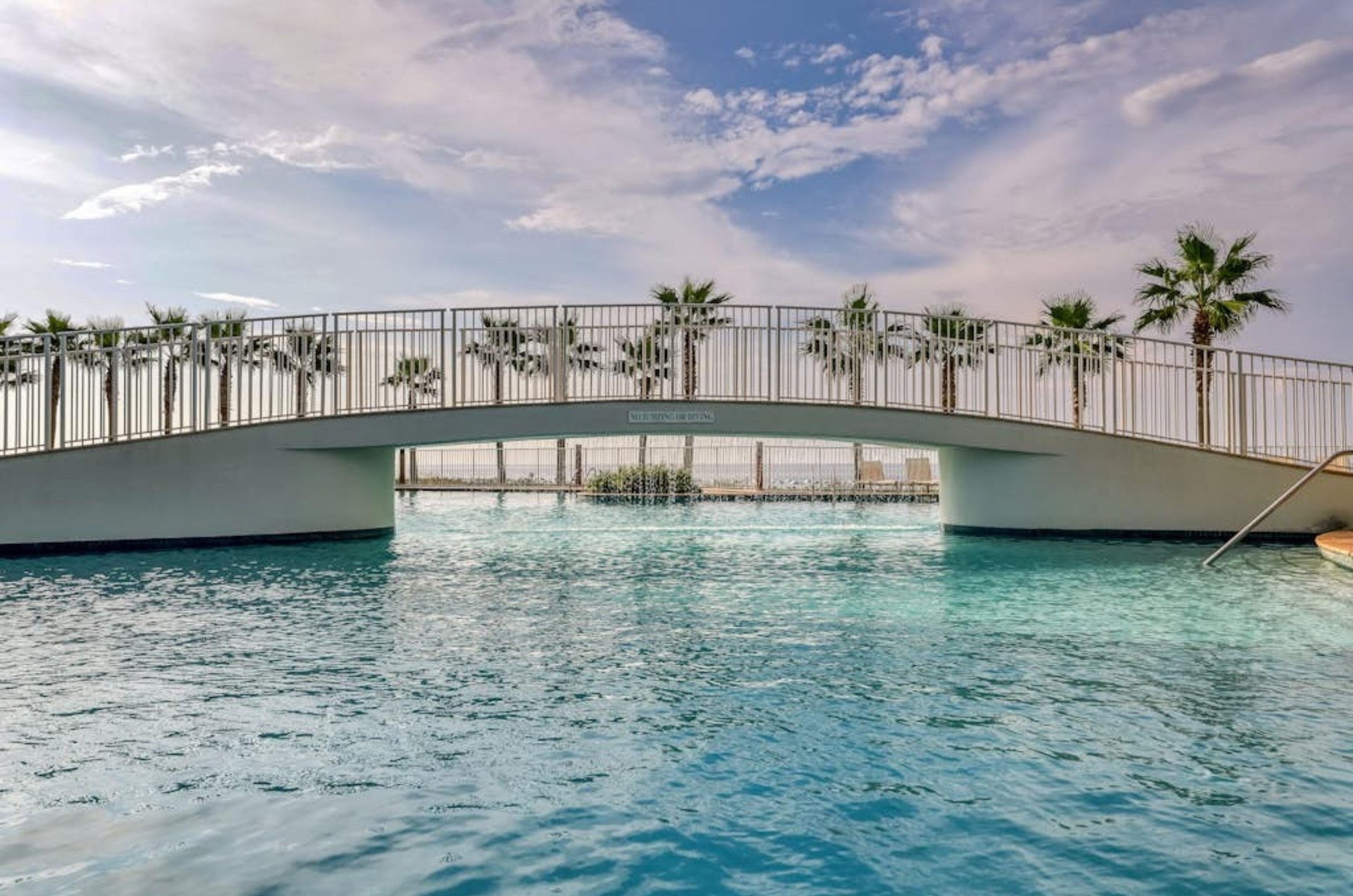 A bridge crossing over the large outdoor swimming pool at Turquoise Place
