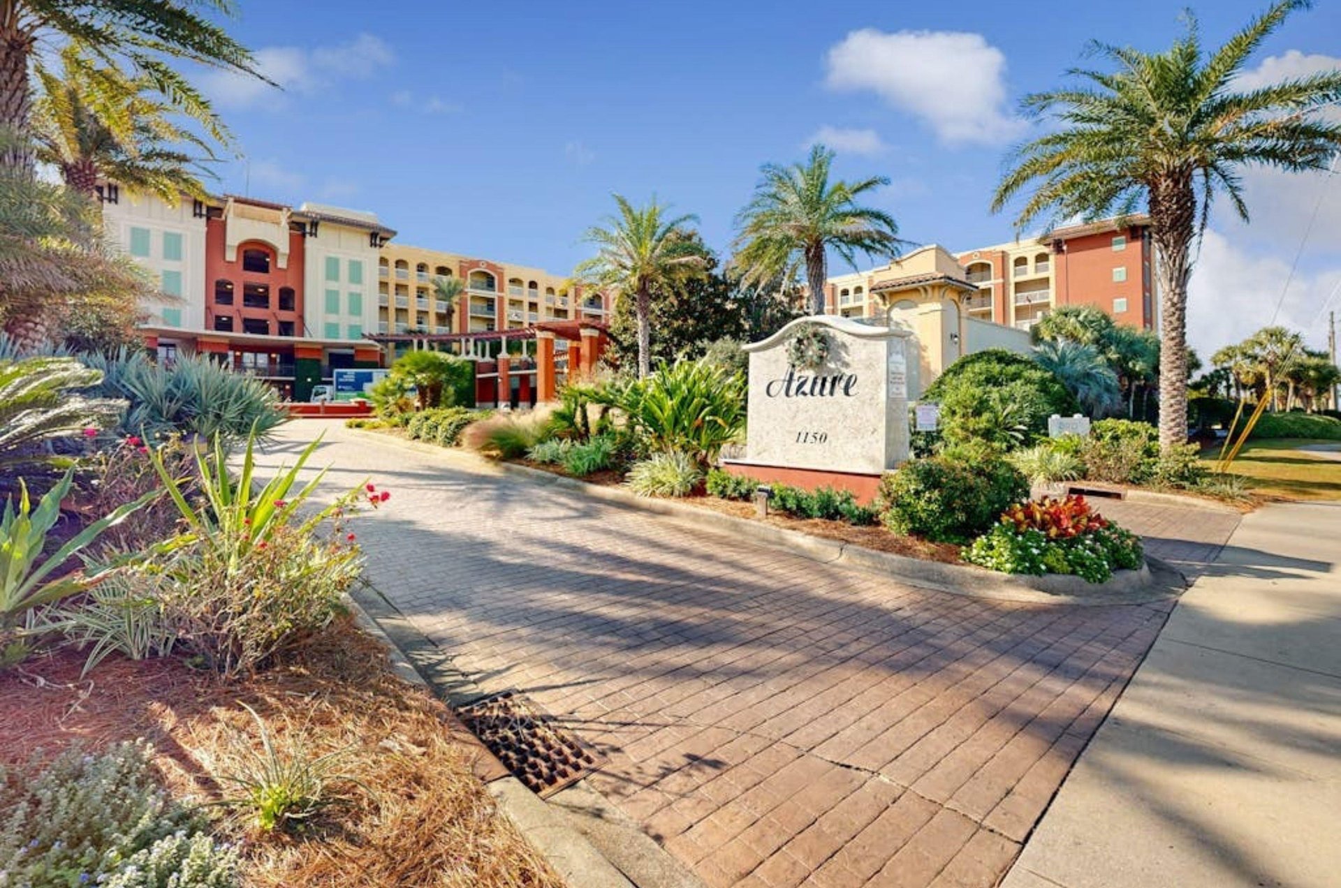 The entry sign and lush greenery around the road leading to Azure Condominiums