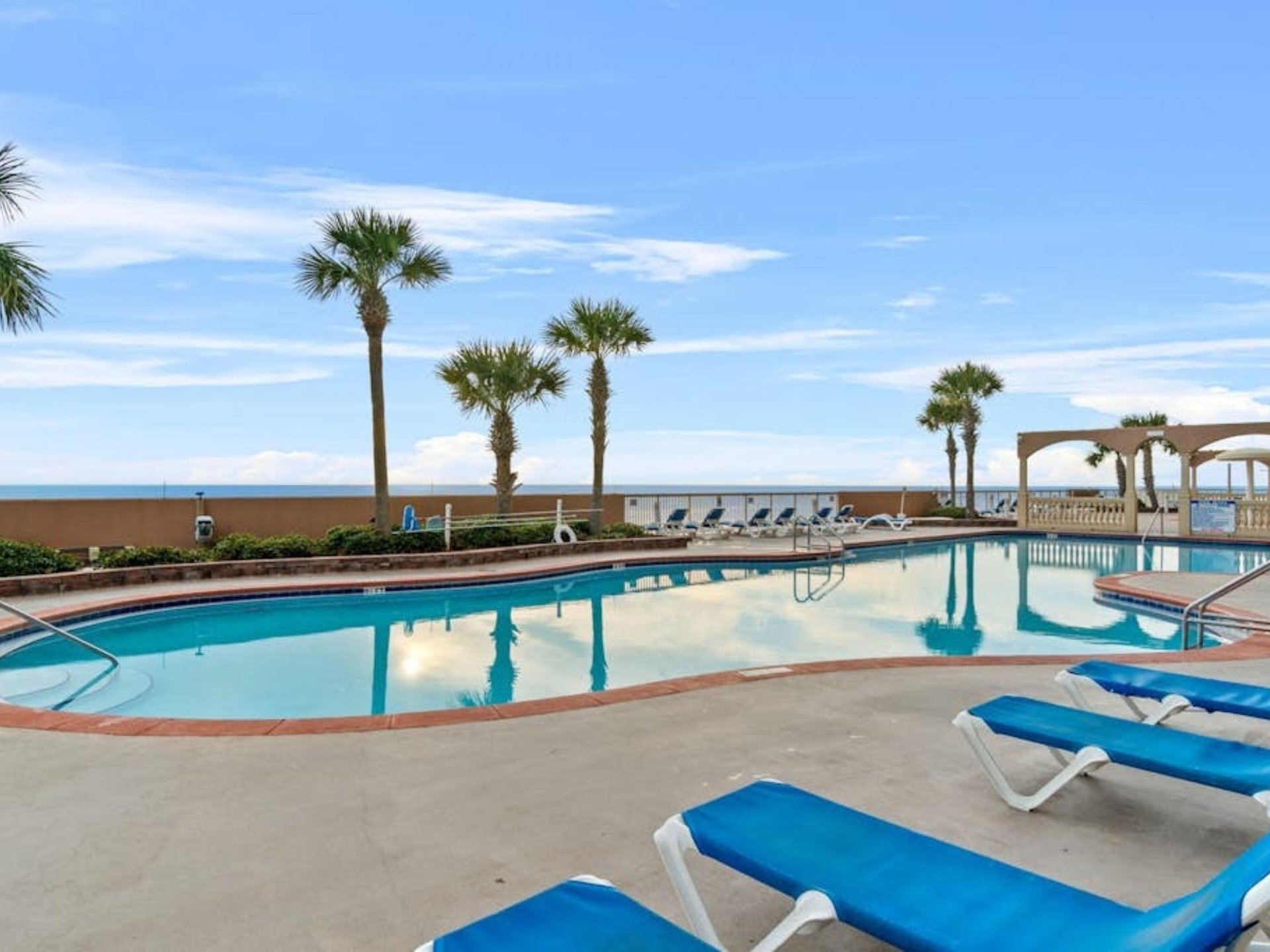 The outdoor swimming pool and pool deck at Sunrise Beach Resort