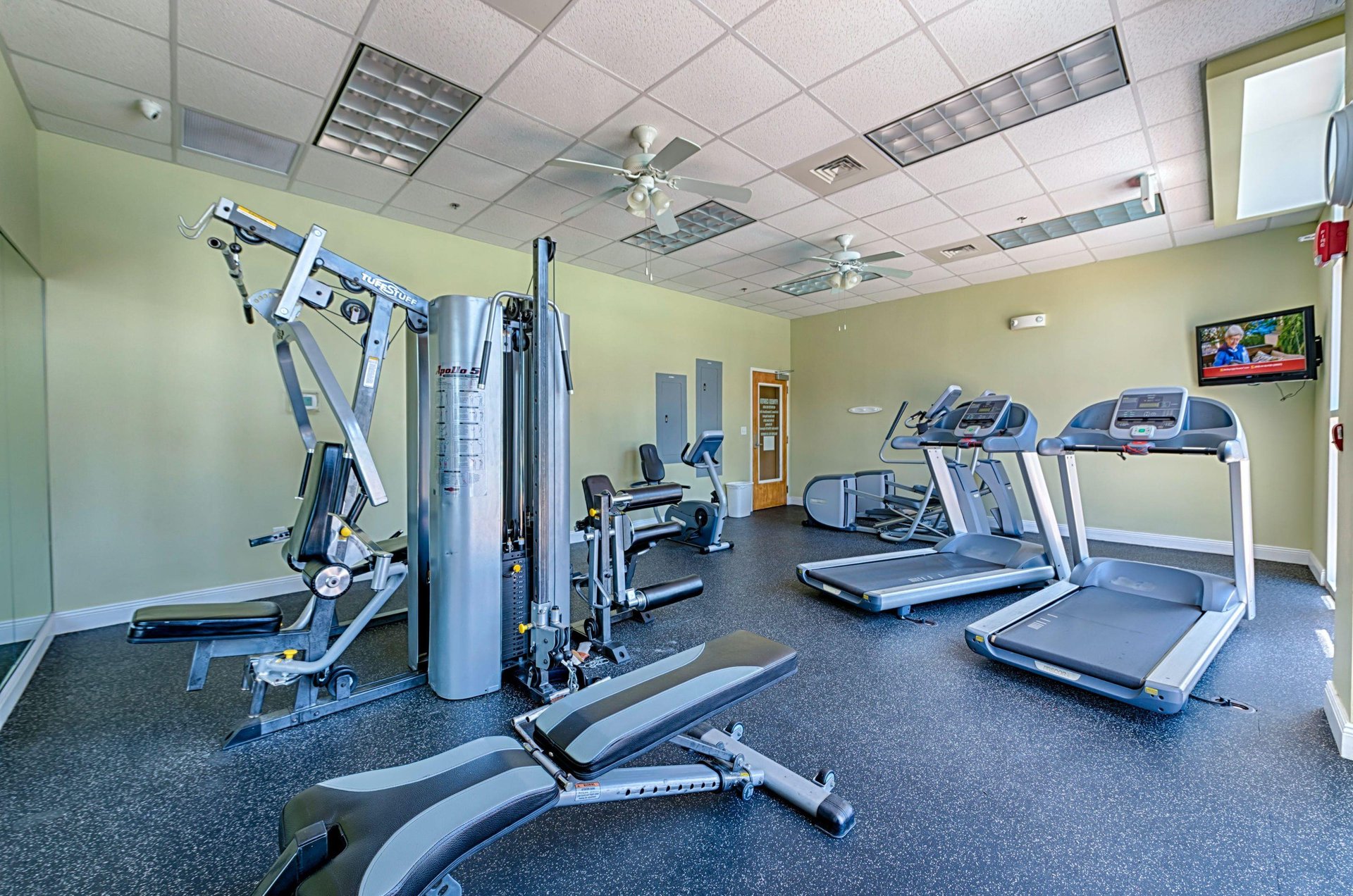 The fitness room is well equipped with machines and a TV to watch while working out.
