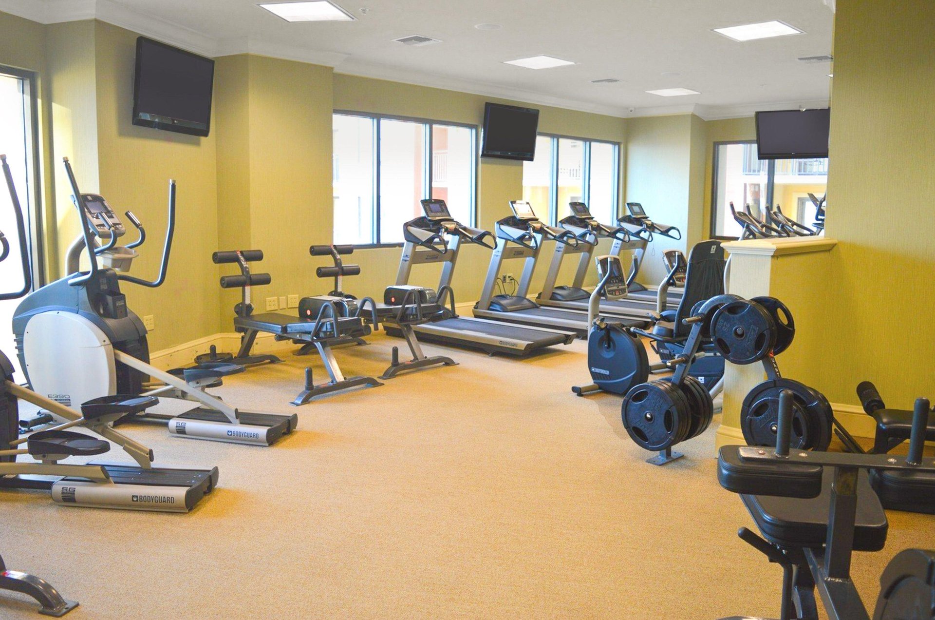 A wellequipped fitness center with TVs to watch while working out.