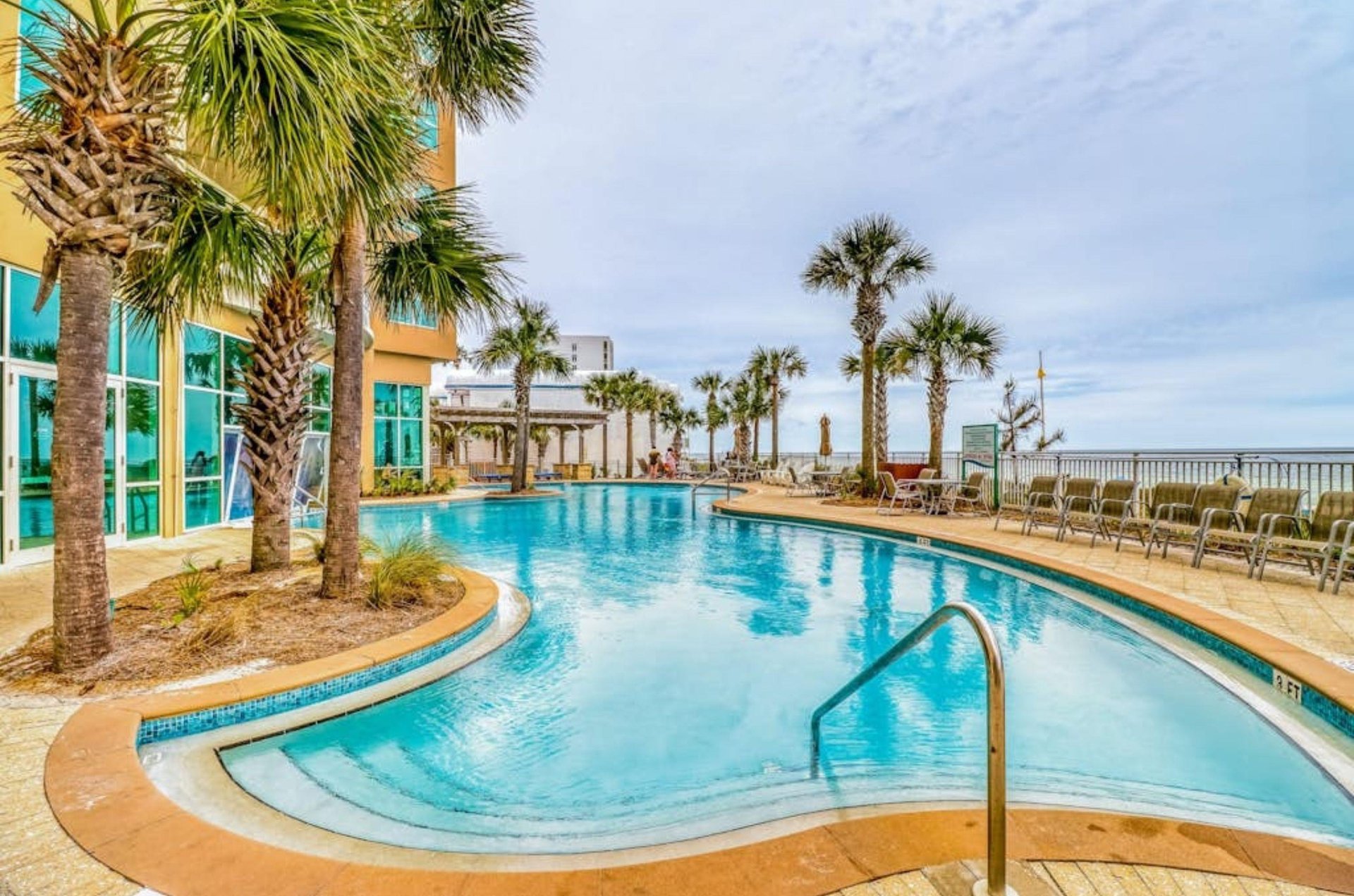 A large blue swimming pool in front of Aqua Resort in Panama City Beach Florida