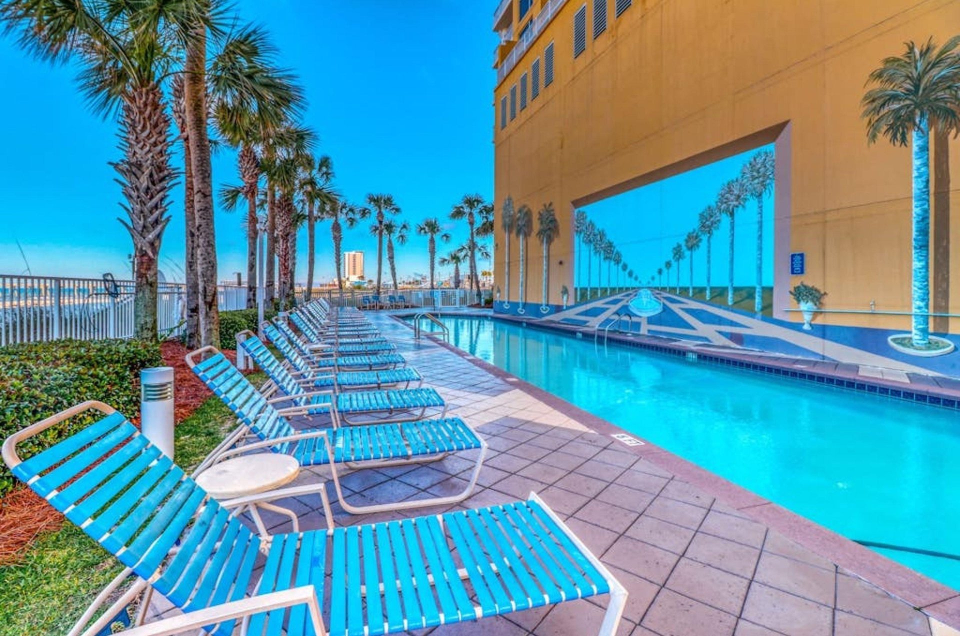 Lounge chairs next to the outdoor swimming pool at Sterling Reef in Panama City Beach Florida