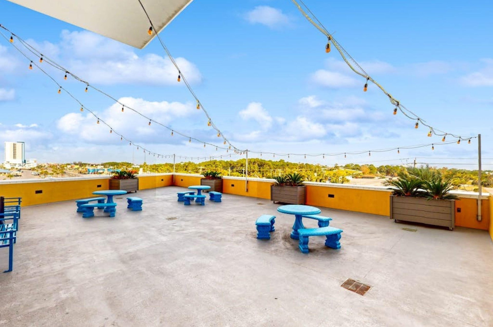 The outdoor terrace with picnic tables and string lights at Sterling Reef in Panama City Beach Florida