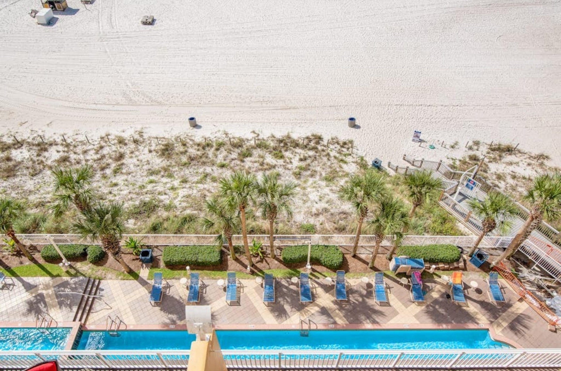 View of the beachside pool deck and boardwalk to the beach from a private balcony