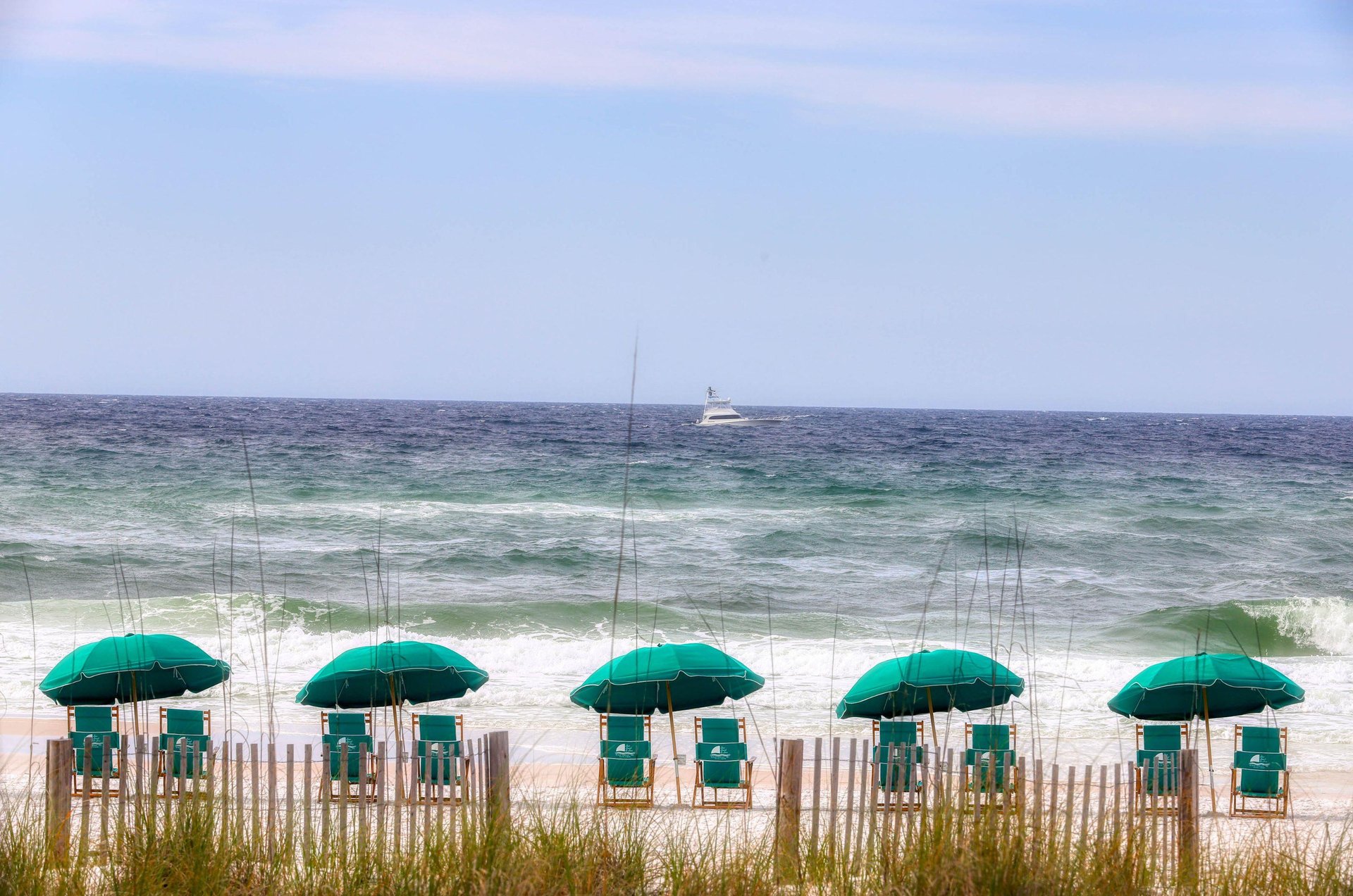 Beach chairs and umbrellas providing frontrow views of the Gulf