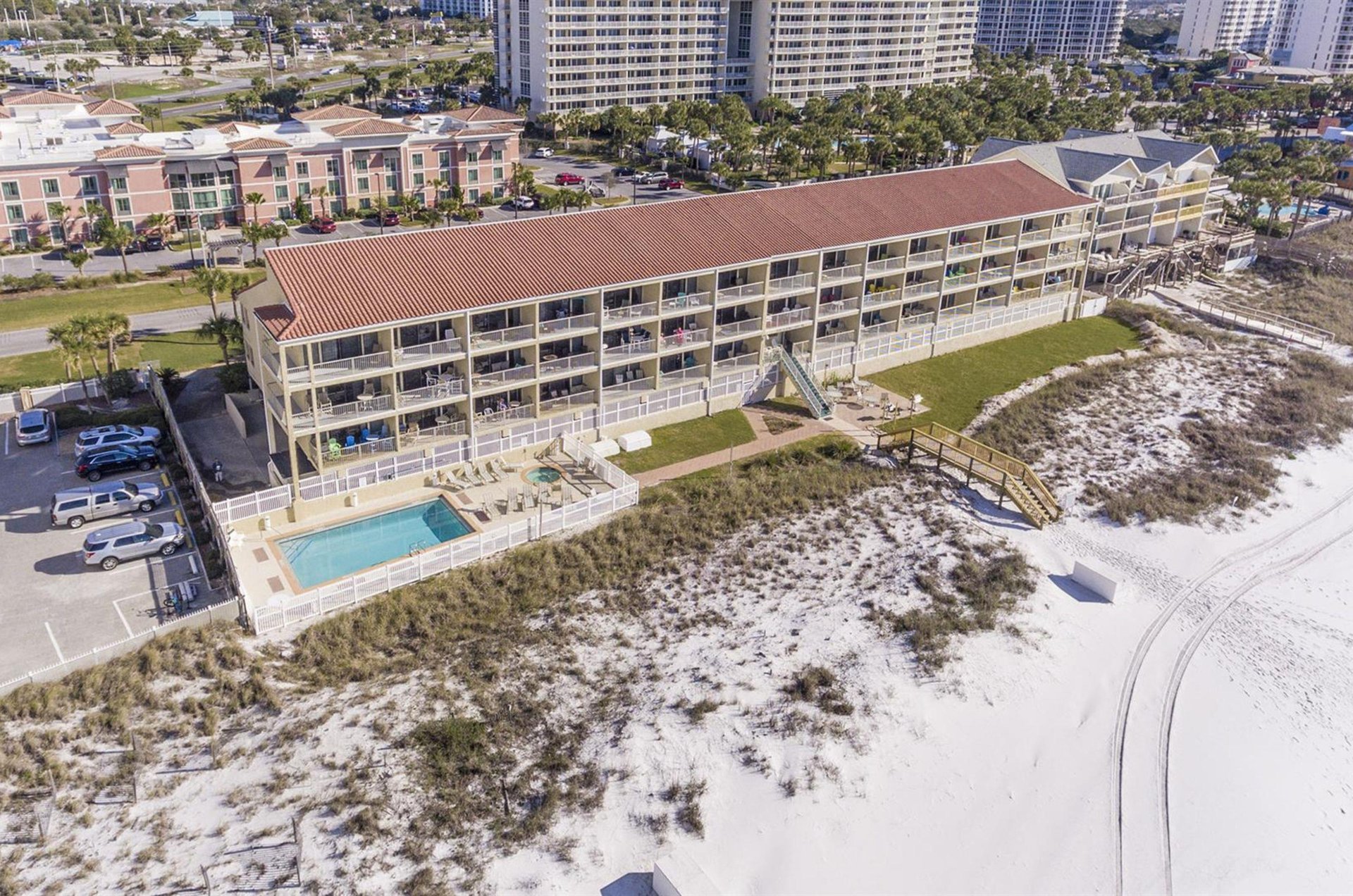 An aerial view of the complex showing the swimming pool, hot tub, and close proximity to the sugary sand beach.
