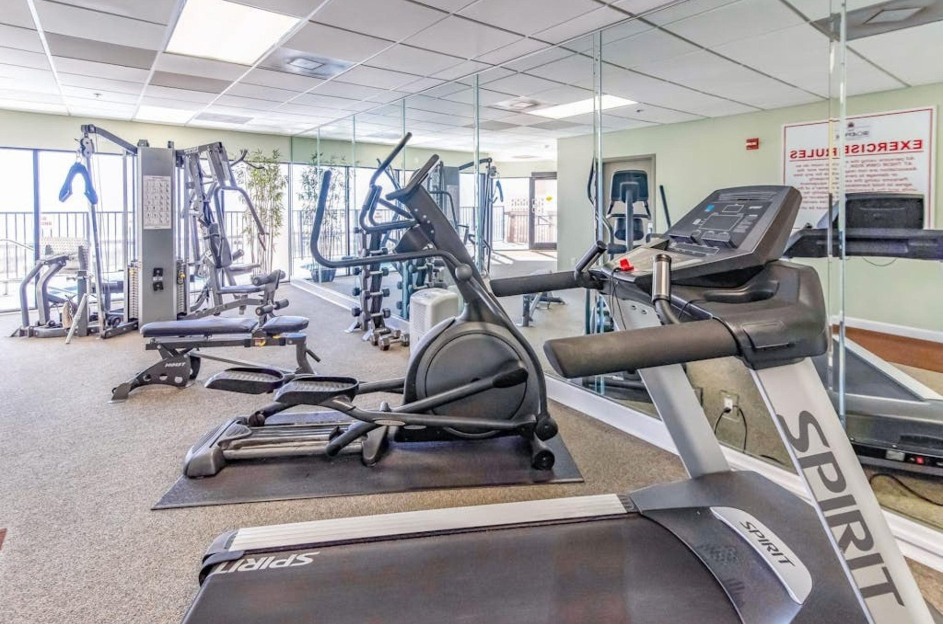Treadmills and cardio equipment in the fitness center next to windows overlooking the Gulf