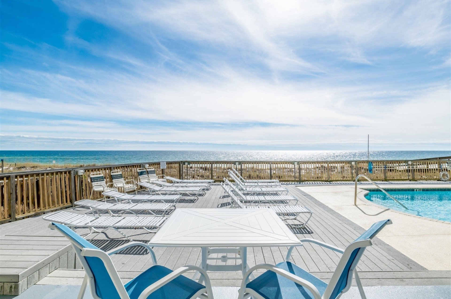 Tables and chairs on the beachfront pool deck at Perdido Skye
