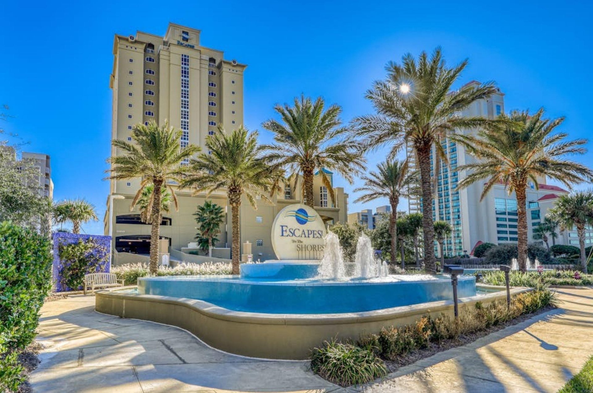 The waterfountain and palm trees in front of Escapes to the Shores in Orange Beach Alabama