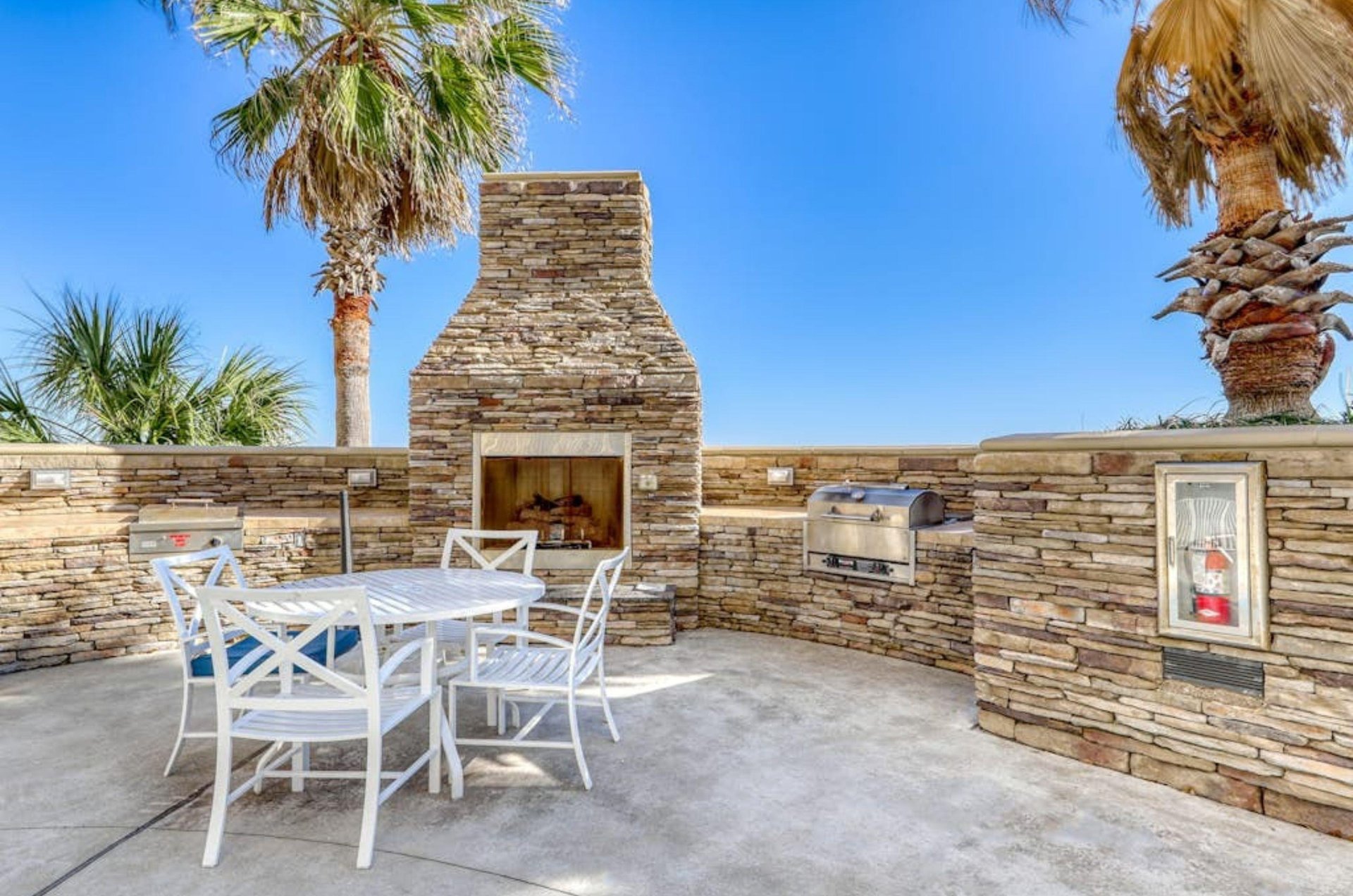 Outdoor grills in a stone wall with a picnic table on a patio at Escapes to the Shores