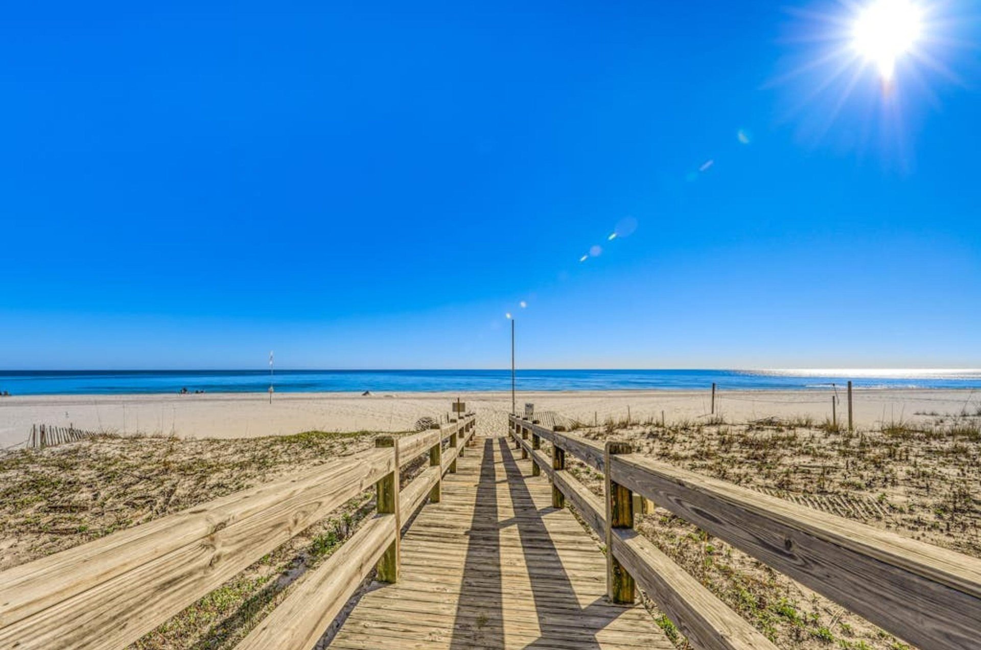 A wooden boardwalk leading to the Gulf at Escapes to the Shores