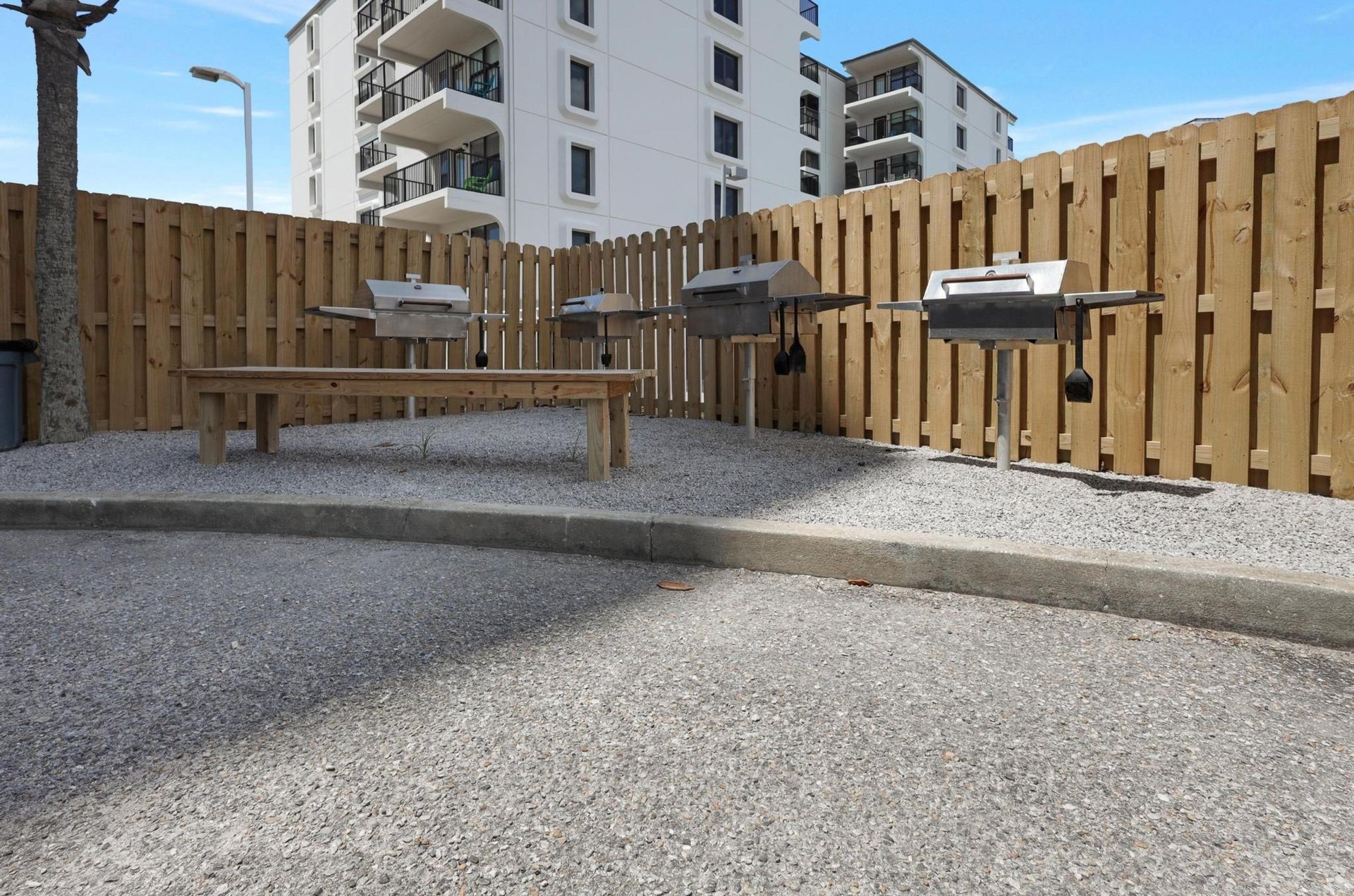 Outdoor barbecue grills on a fencedin patio at Lighthouse Condominiums