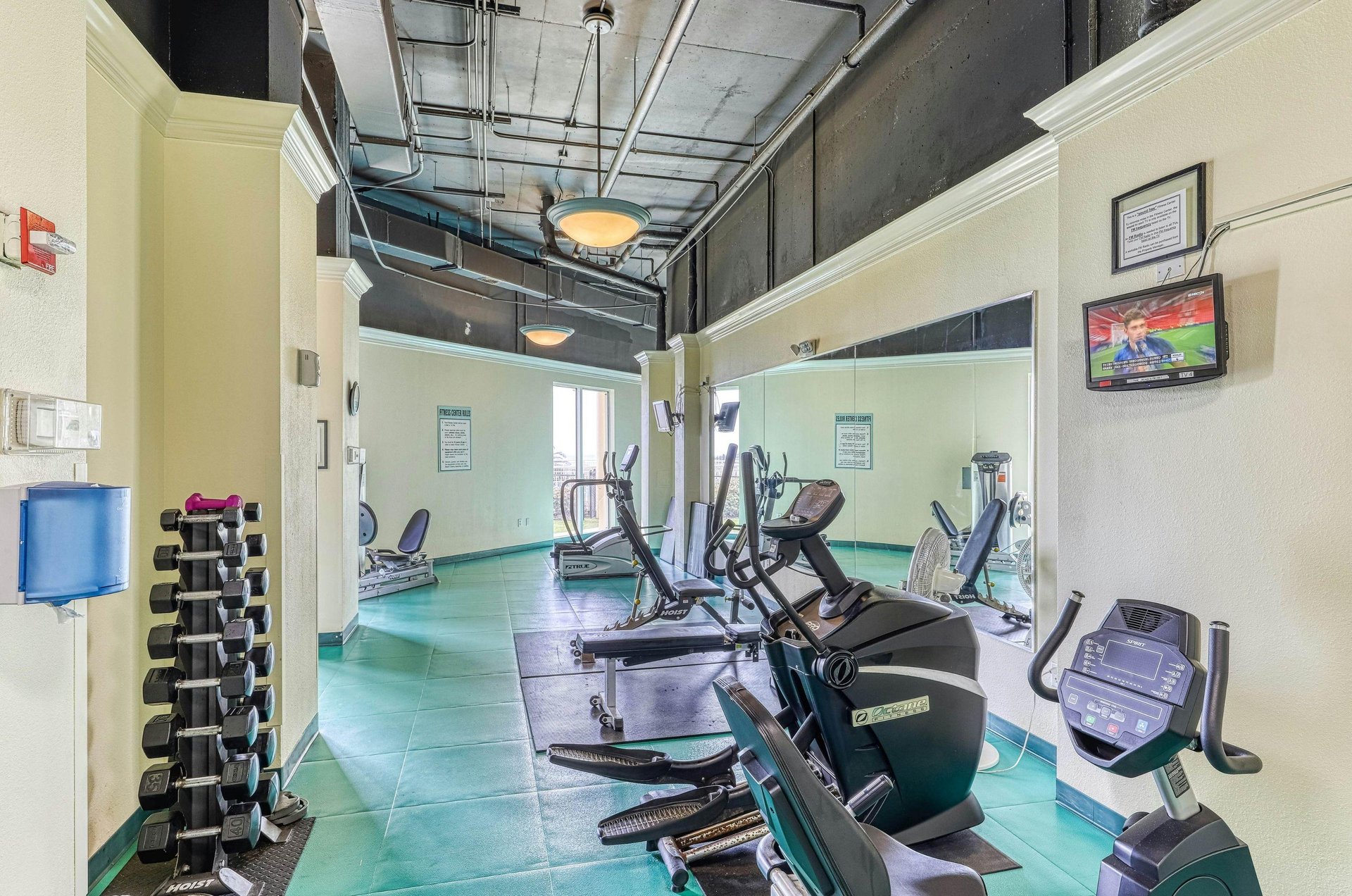Free weights and bikes in the fitness center at Beach Colony Resort