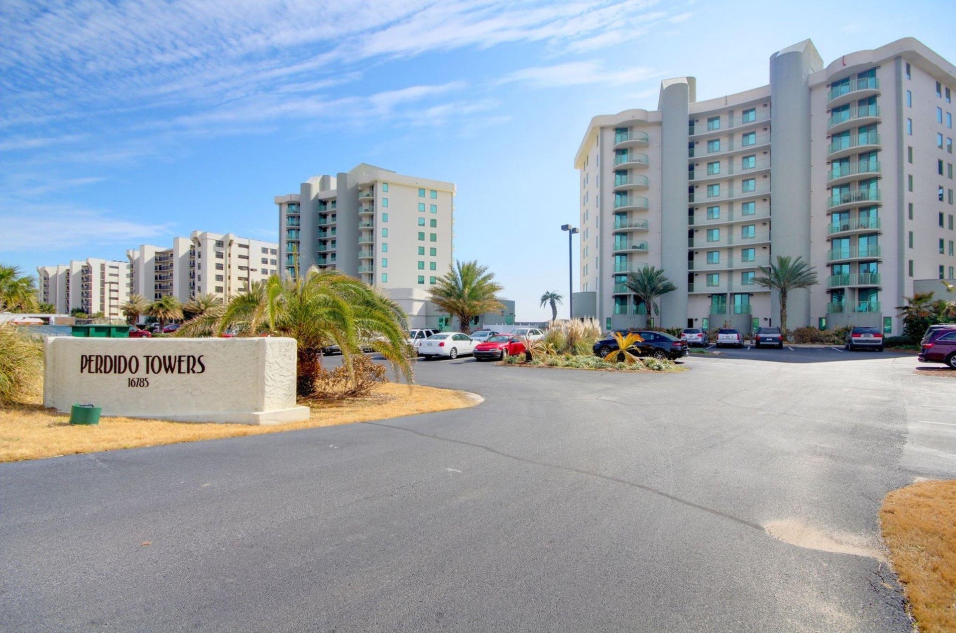 View from the street of Perdido Towers and the propertys entry sign and parking lot